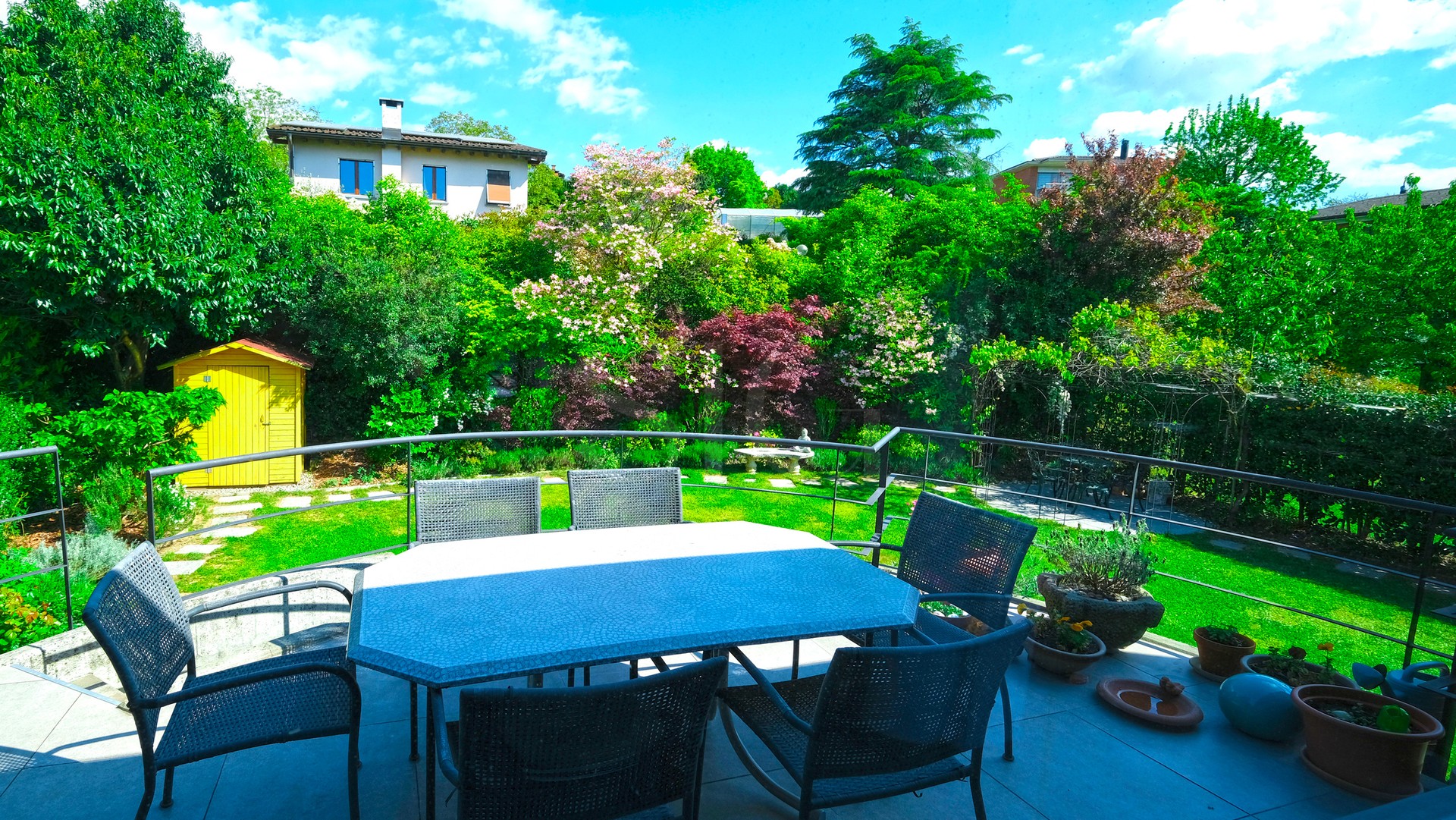 Große Gartenterrasse mit Blick in einen üppigen Garten