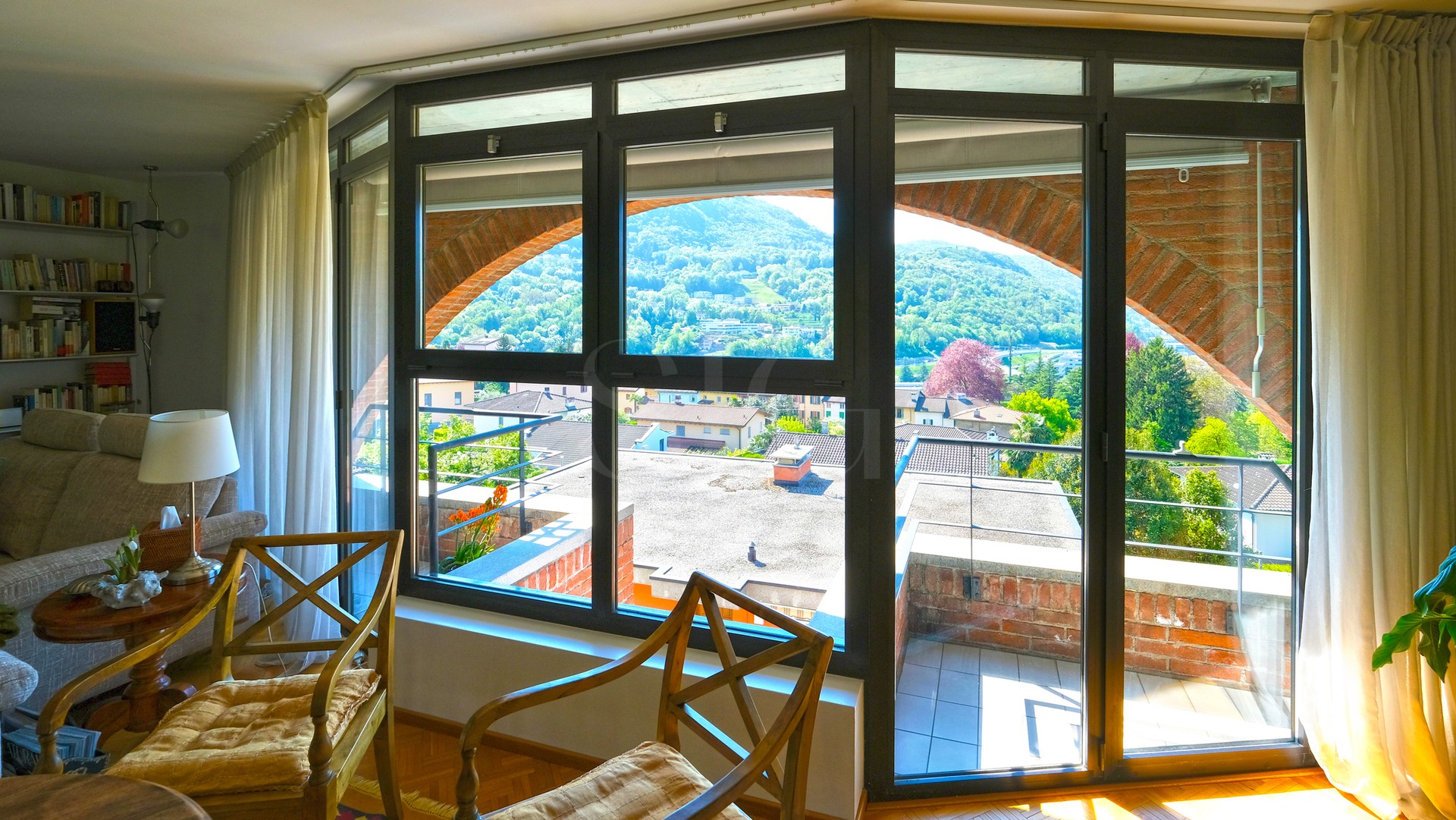 Wohnzimmer mit Panoramafenster und Balkonblick