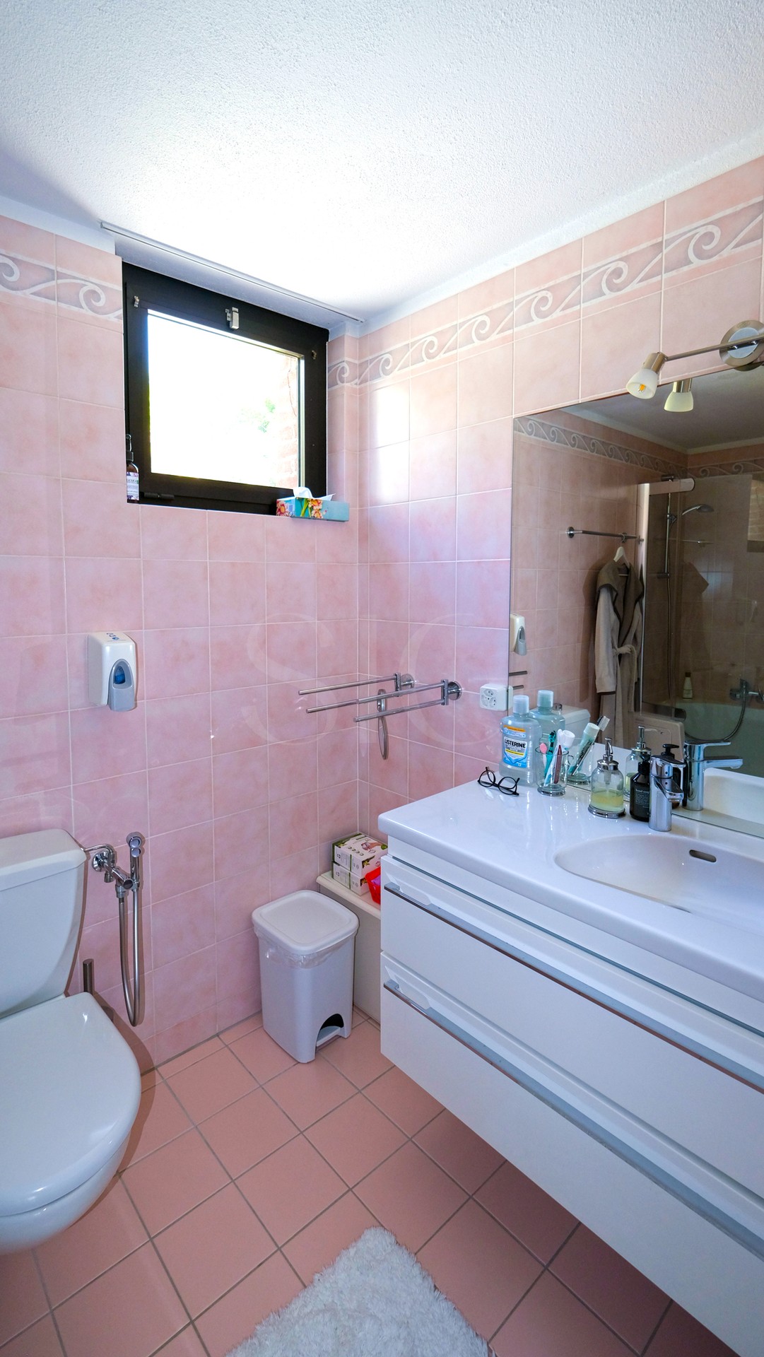 Helles Badezimmer mit rosa Fliesen