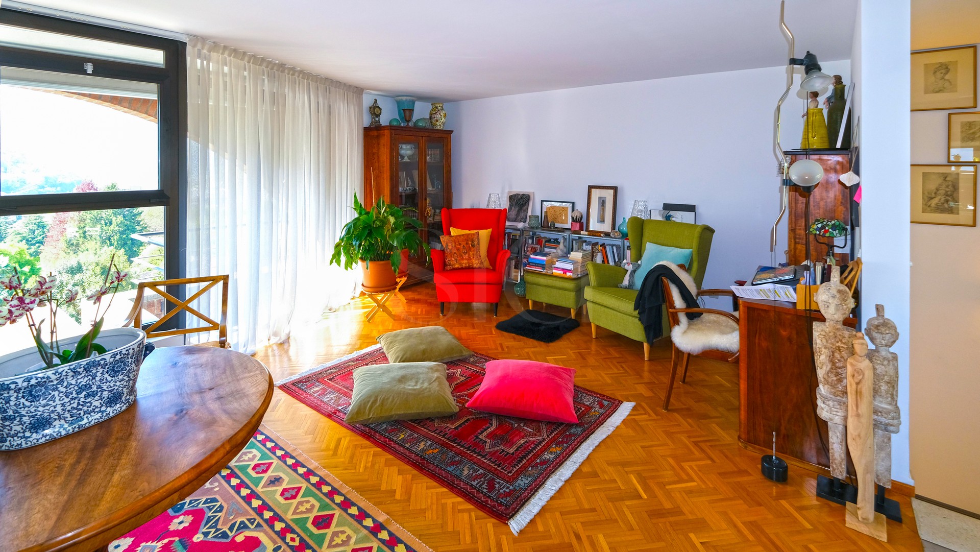 Wohnzimmer mit großem Fenster und bunter Einrichtung