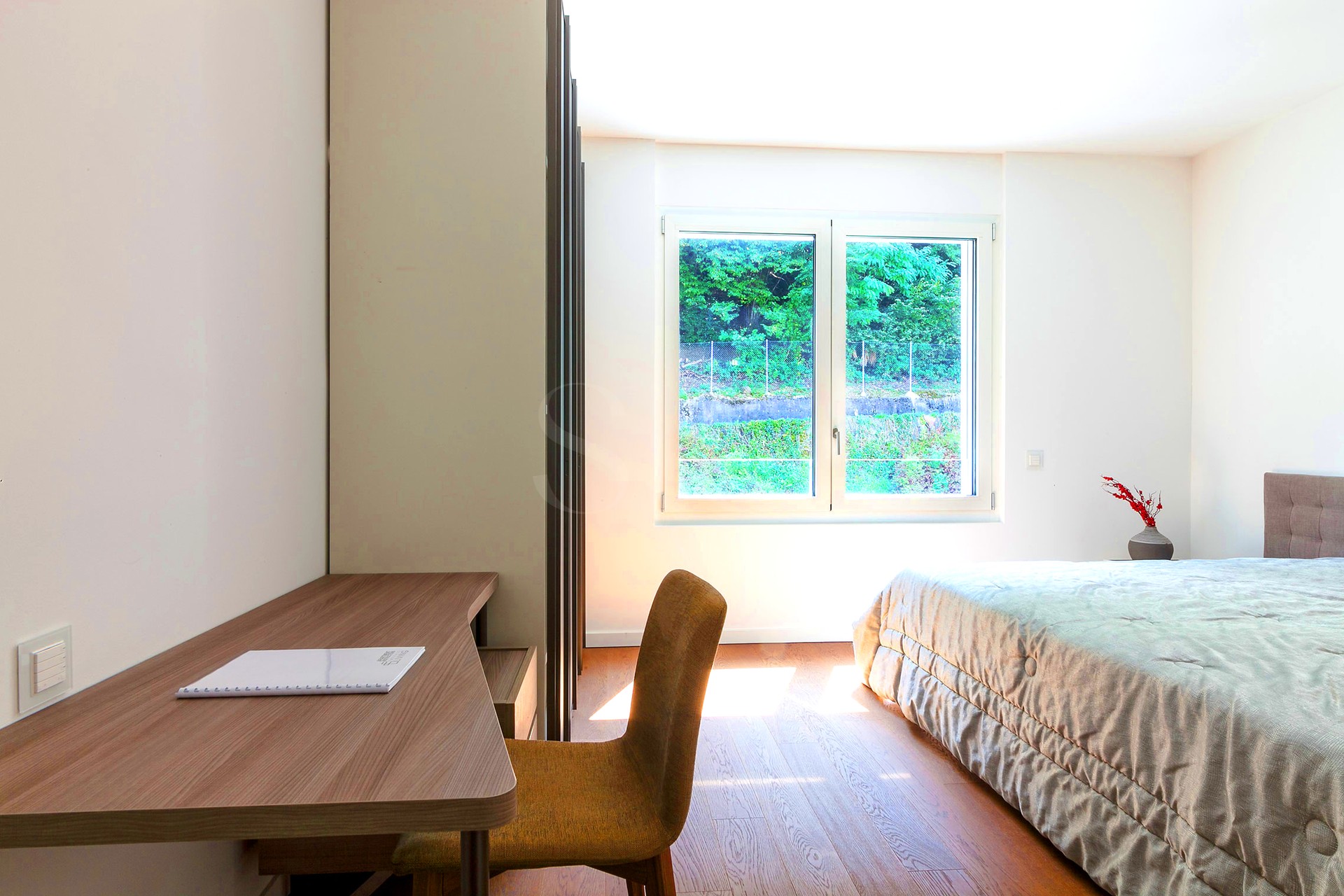 Helles Schlafzimmer mit Arbeitsplatz am Fenster