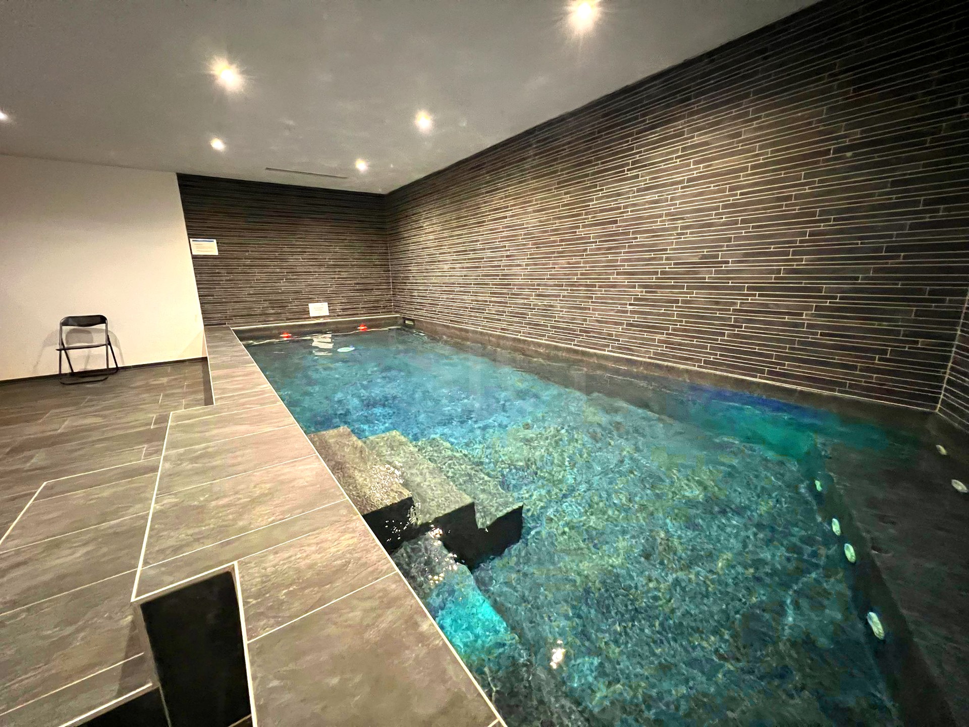 Innenpool mit dunkler Steinoptik