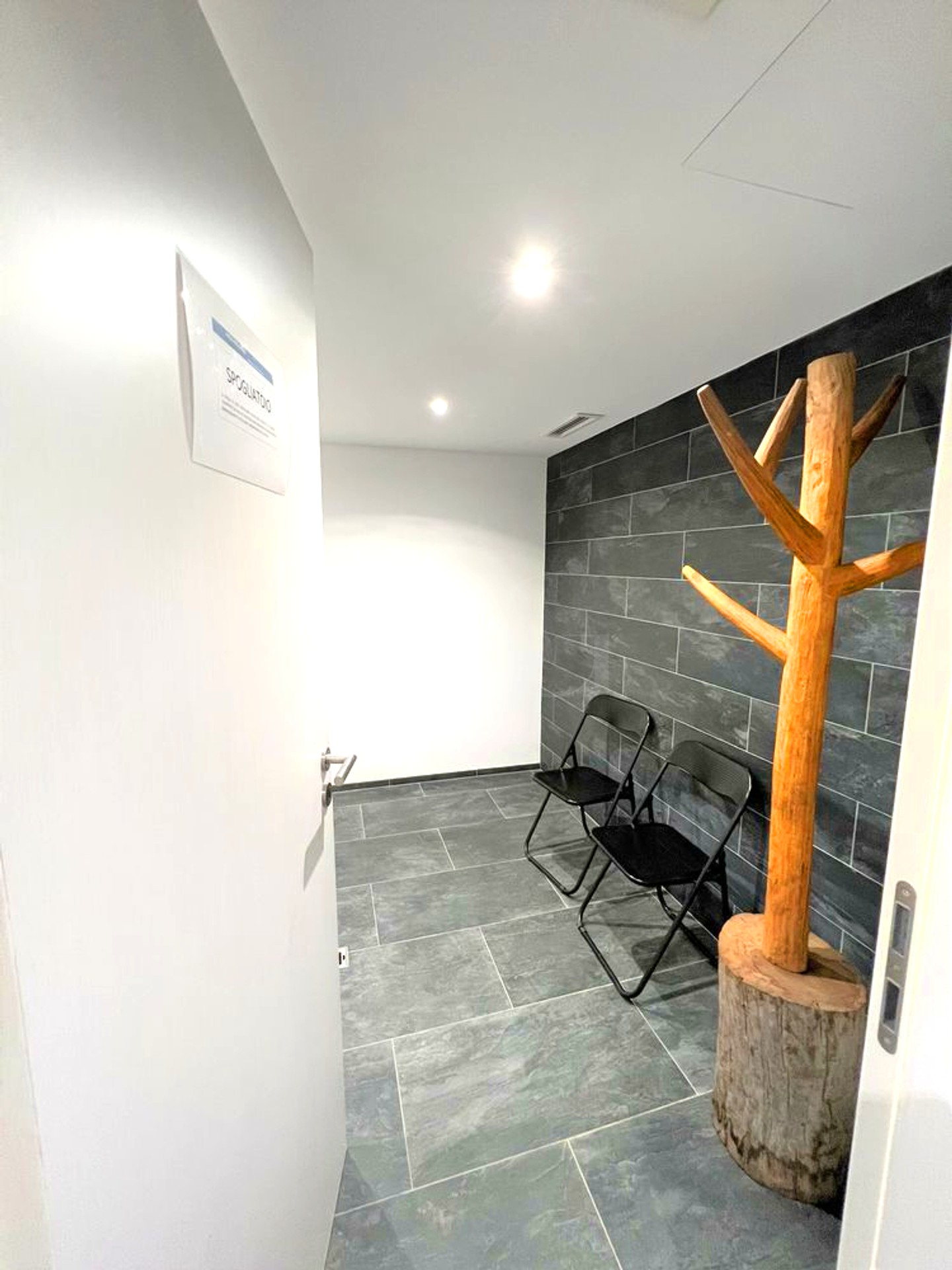 Moderner Flur mit dunkler Steinoptik und Garderobe