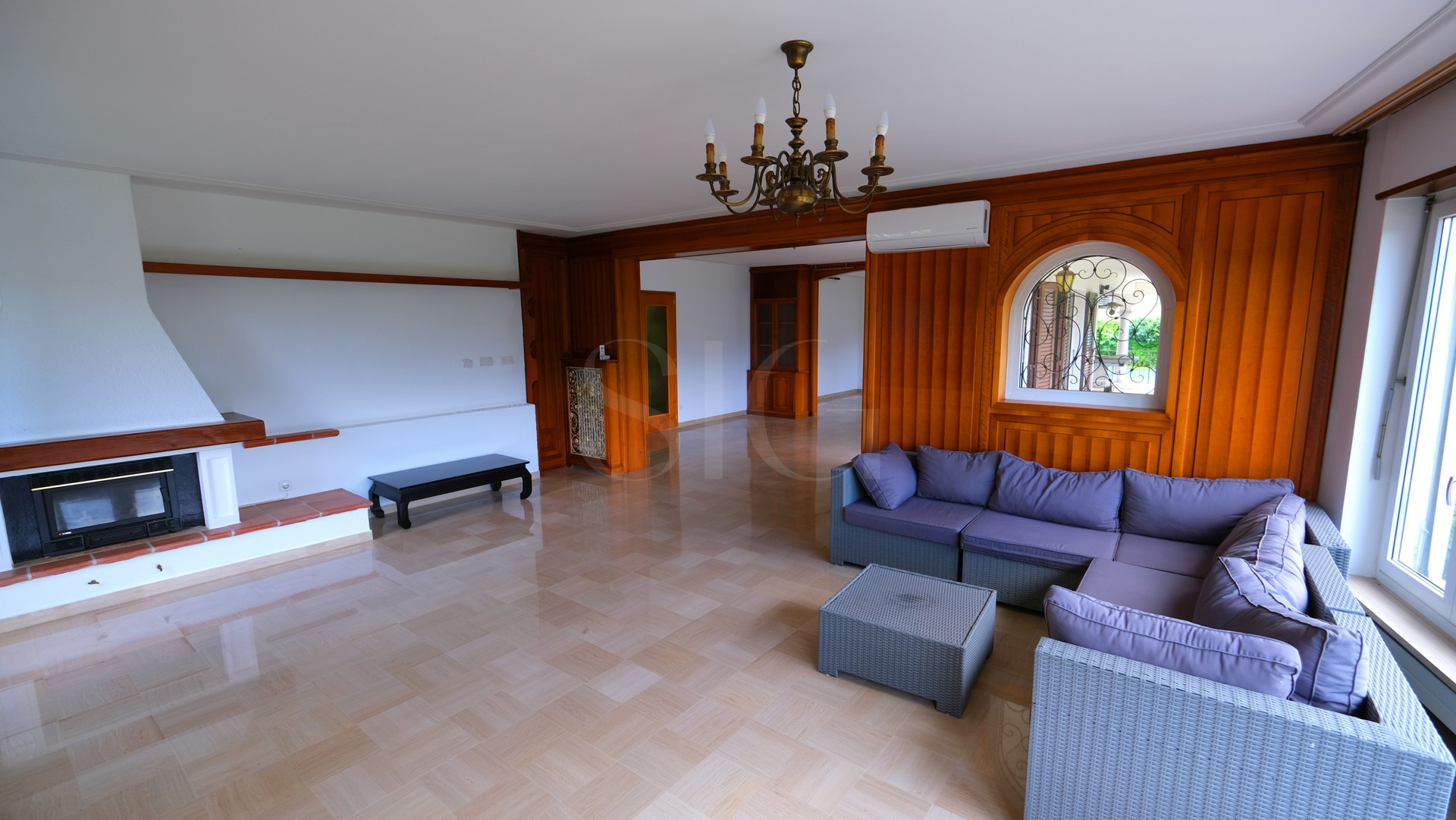 Wohnzimmer mit Kamin und Holzvertäfelung