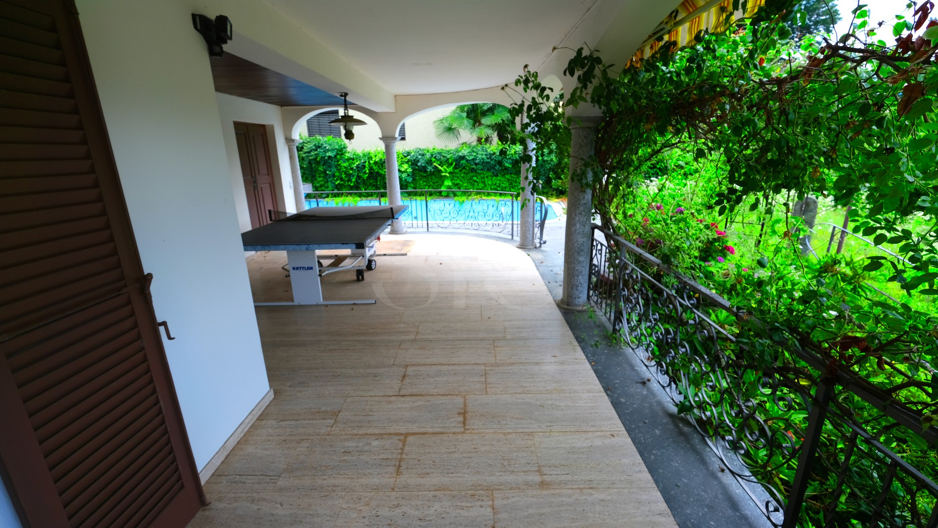 Überdachte Terrasse mit Gartenblick