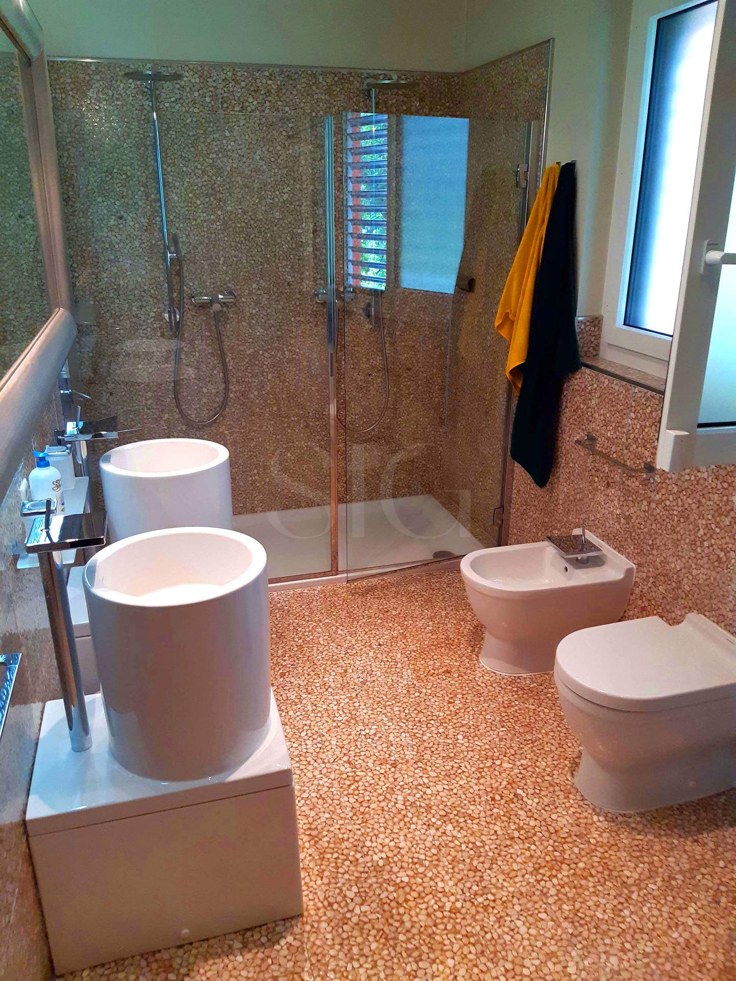 Modernes Badezimmer mit Natursteinmosaik und Glasdusche
