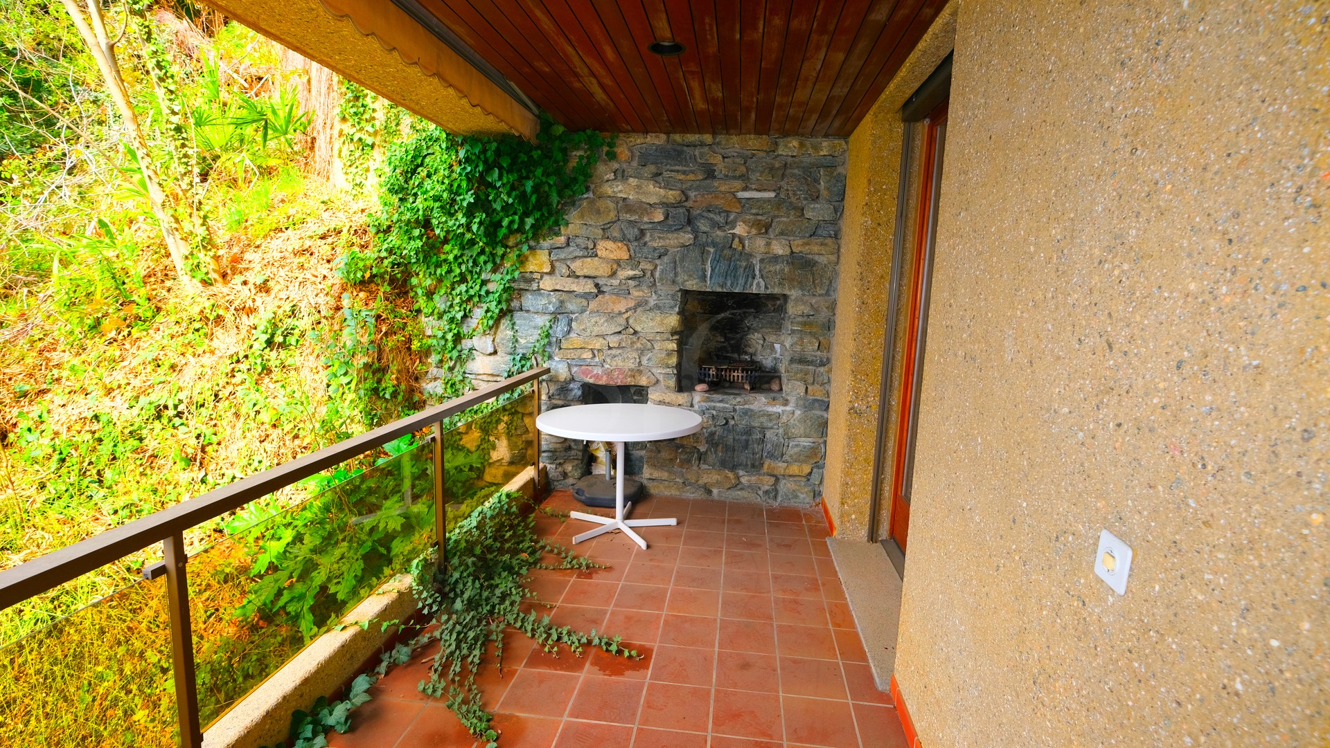 Überdachte Terrasse mit Steinwand und Grillnische