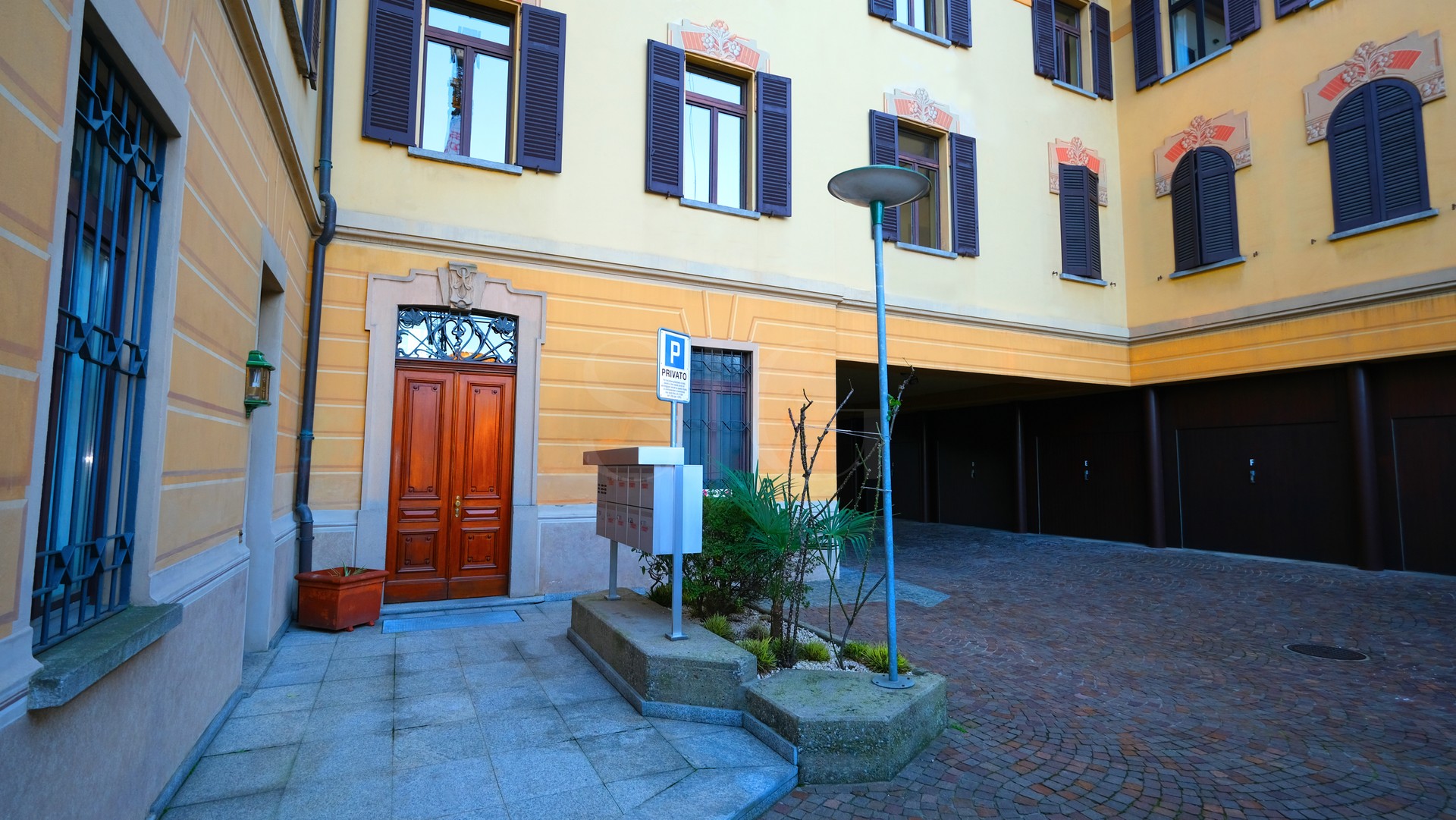 Innenhof eines historischen Wohngebäudes mit Arkade und Garagenzufahrt