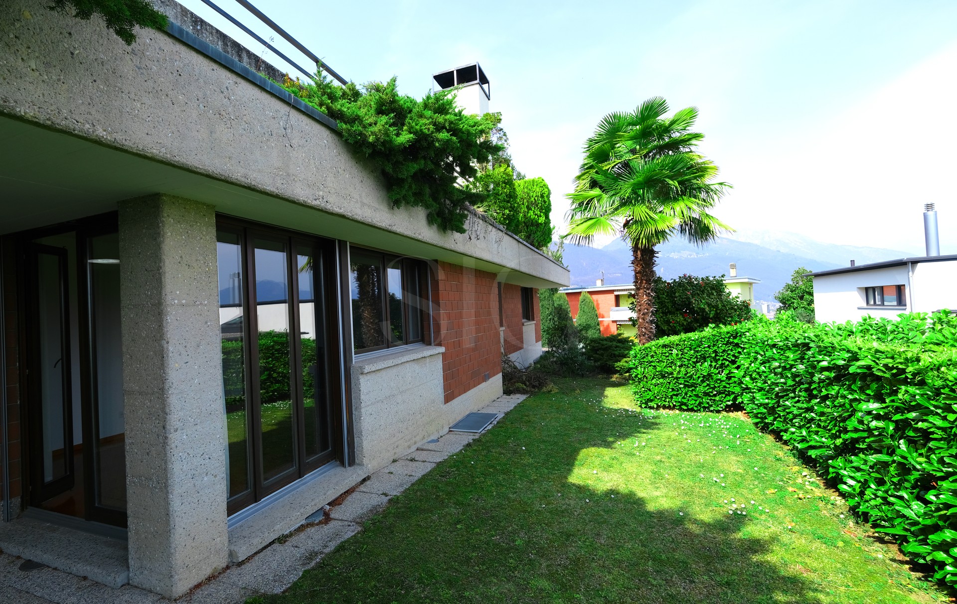 Gartenansicht eines modernen Hauses mit Bergblick