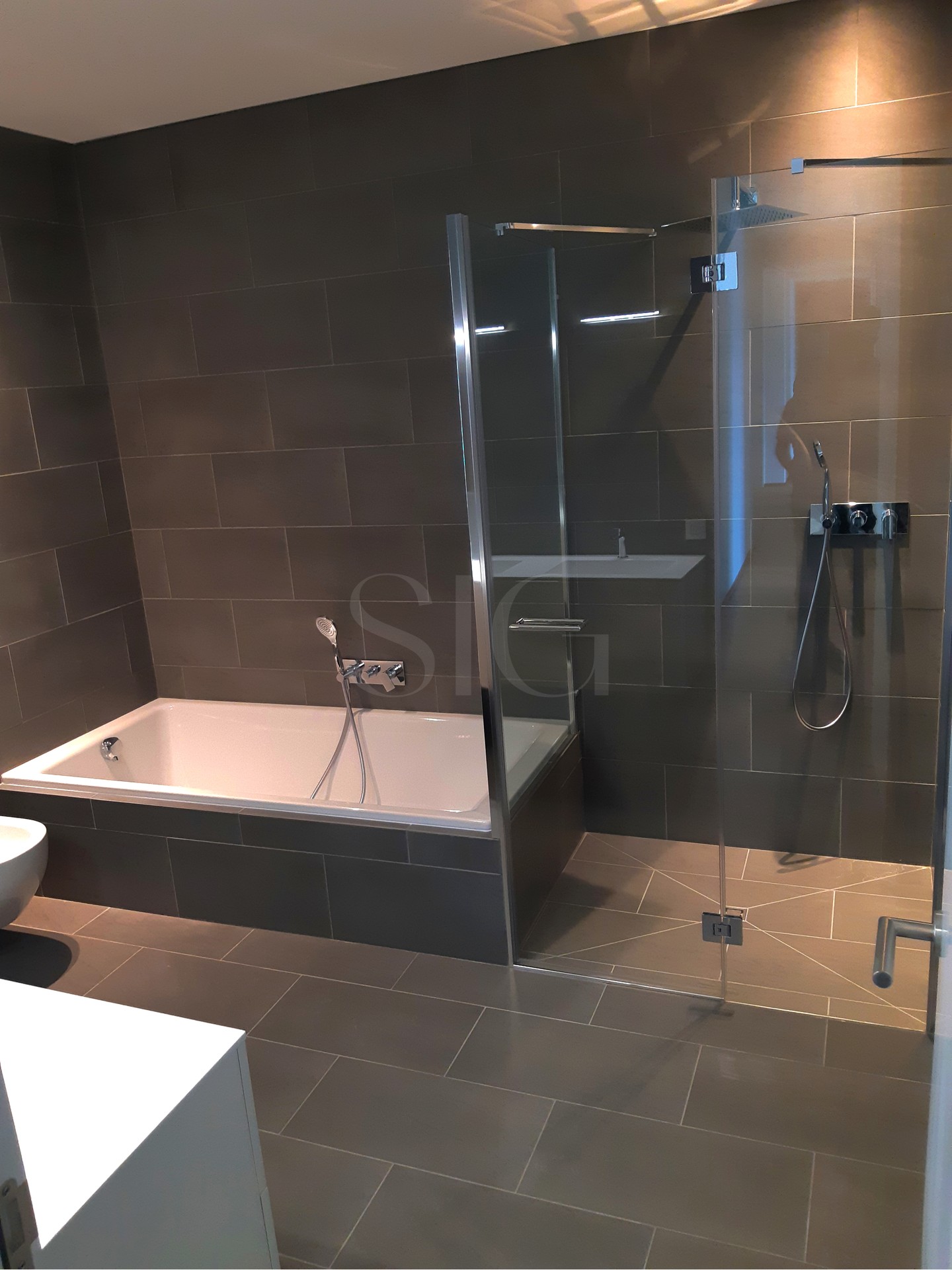 Modernes Badezimmer mit Badewanne und Glasdusche