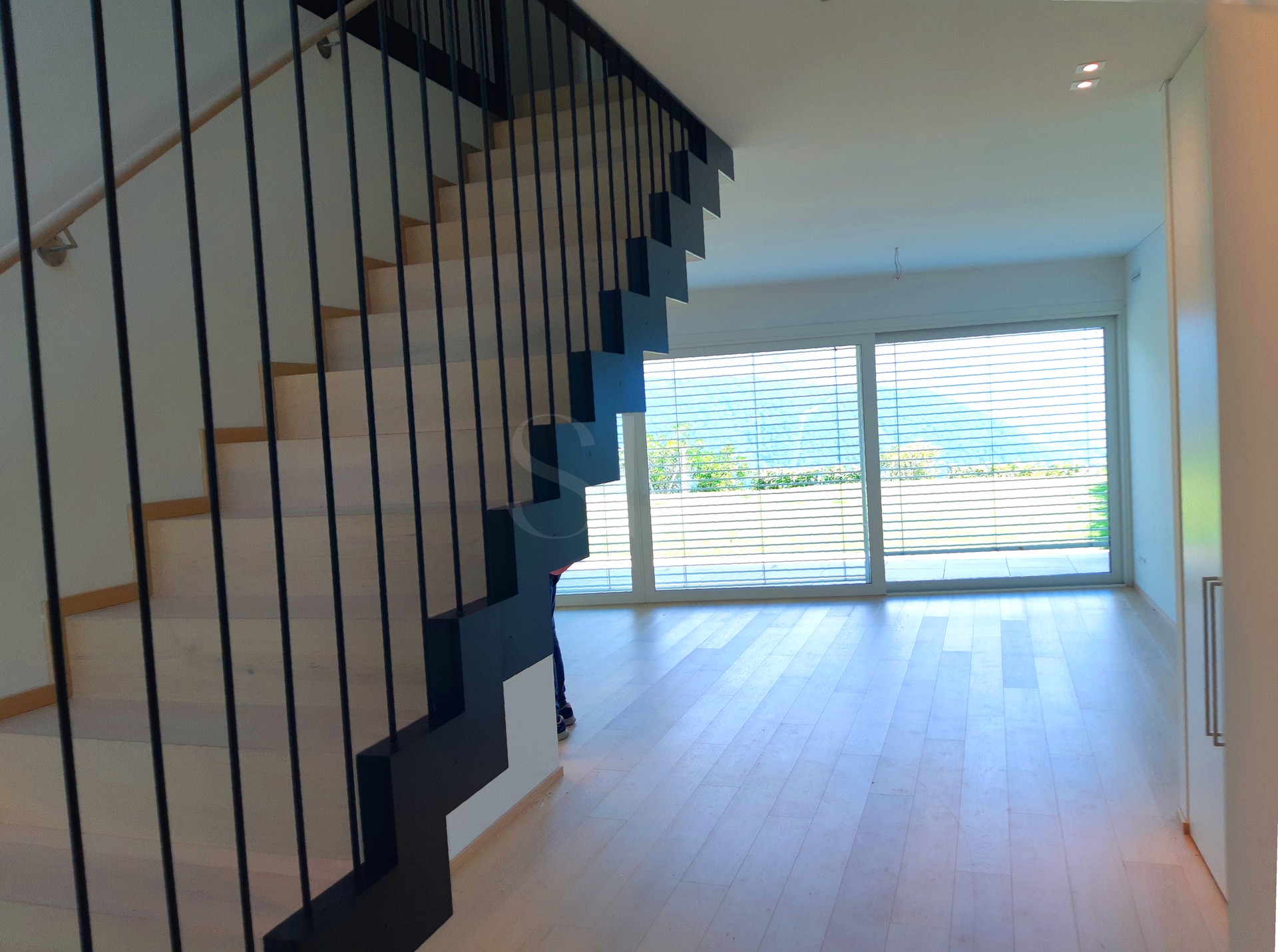 Offener Wohnbereich mit Treppe und großer Fensterfront