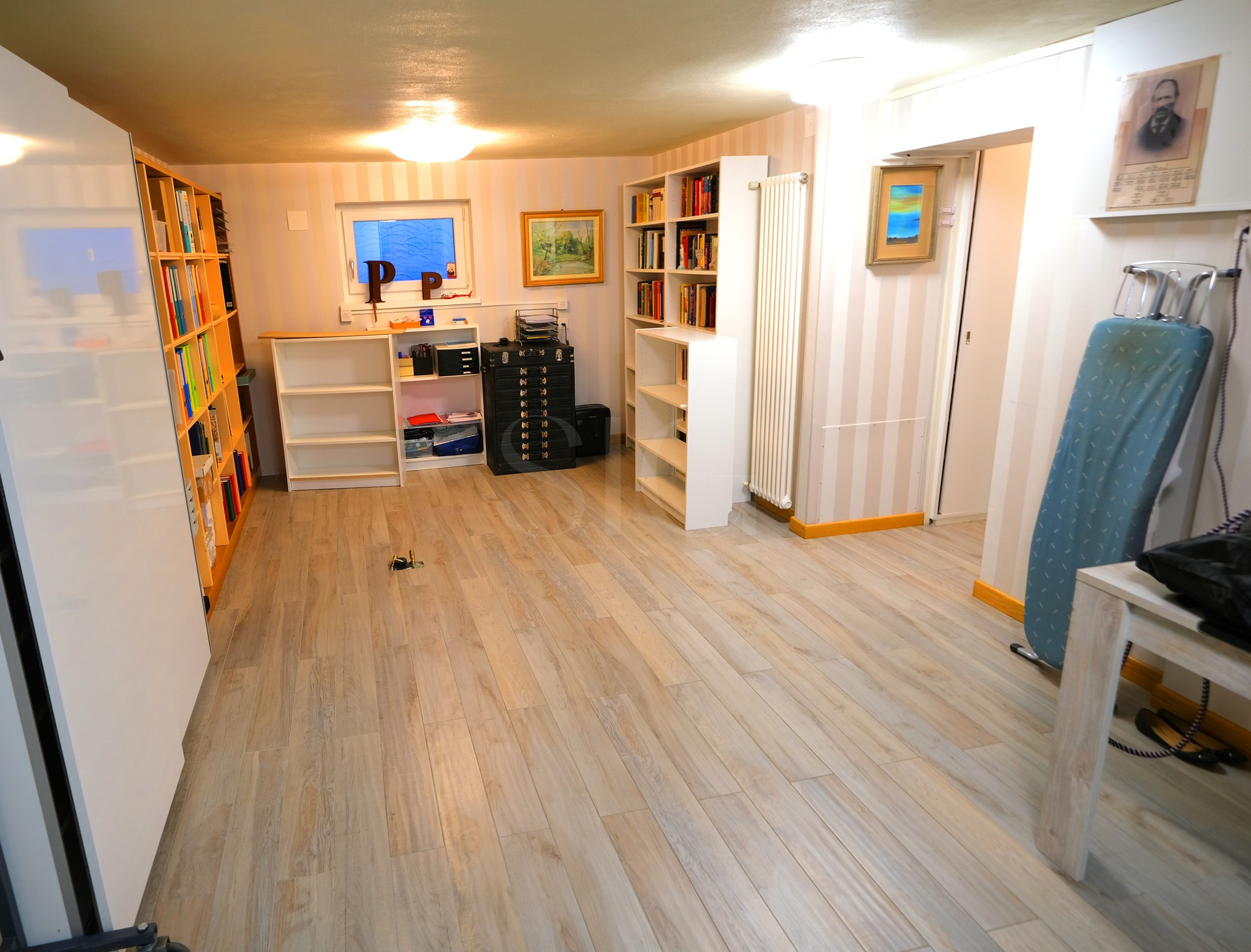 Arbeitszimmer mit Regalen und Holzboden