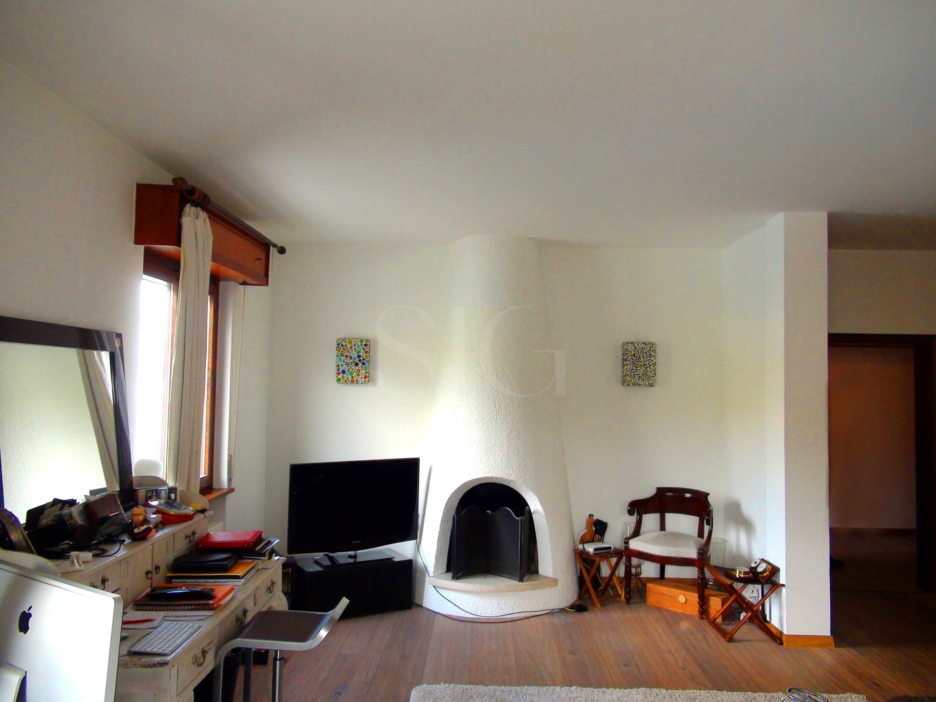 Wohnzimmer mit Kamin und Arbeitsbereich