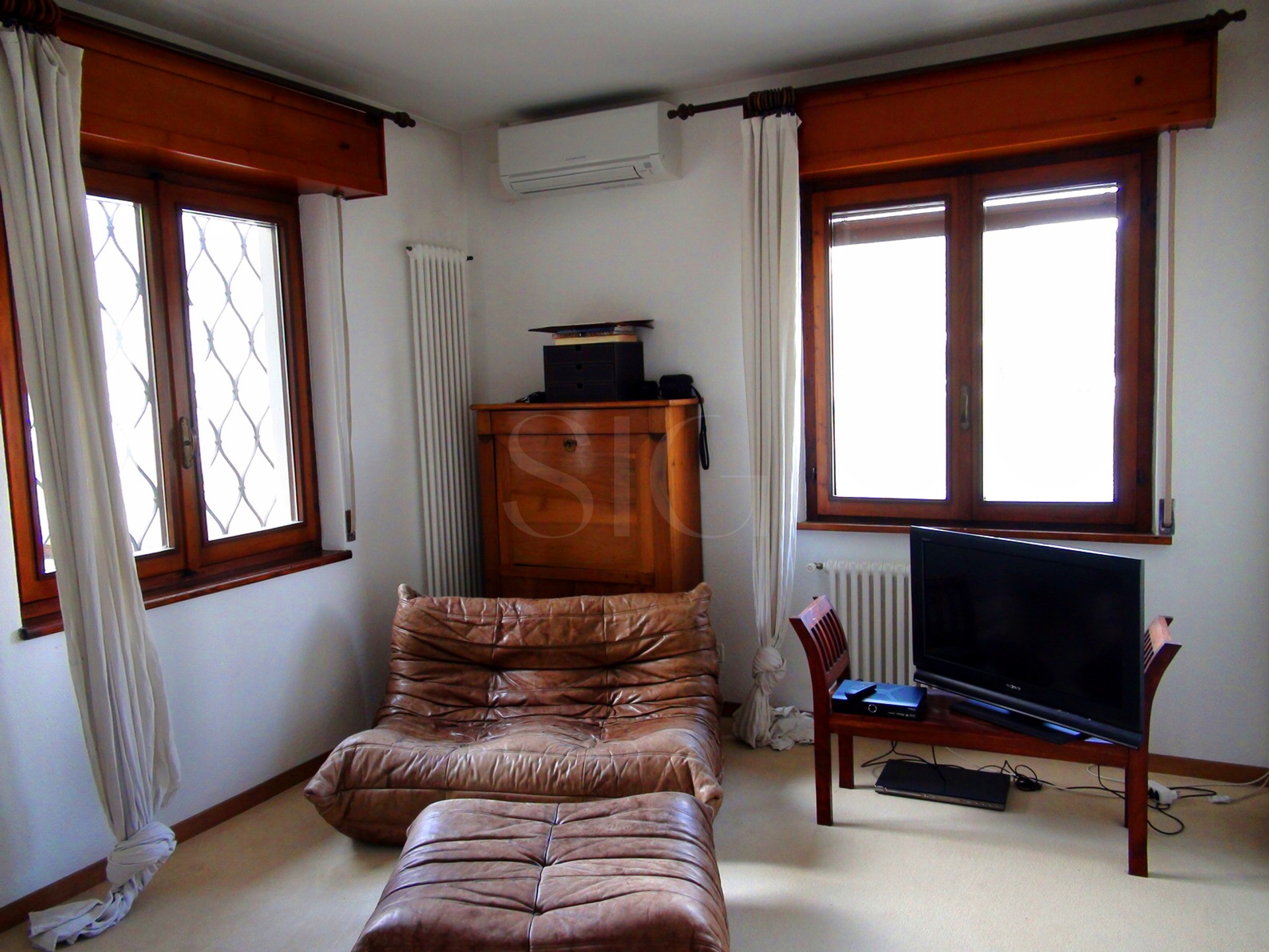 Helles Wohnzimmer mit Fenstern und TV-Ecke