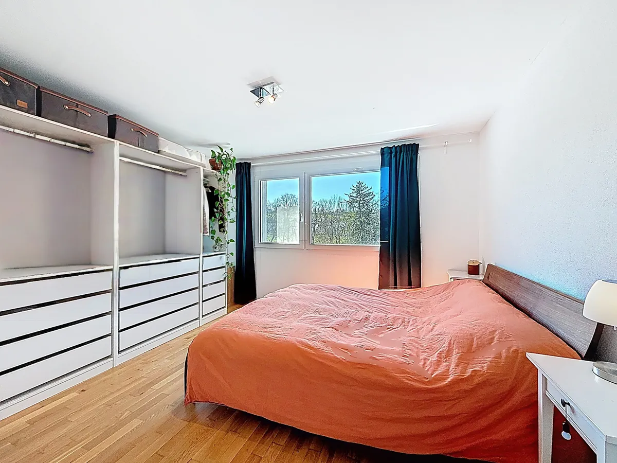 Helles Schlafzimmer mit großem Bett und Schrankwand