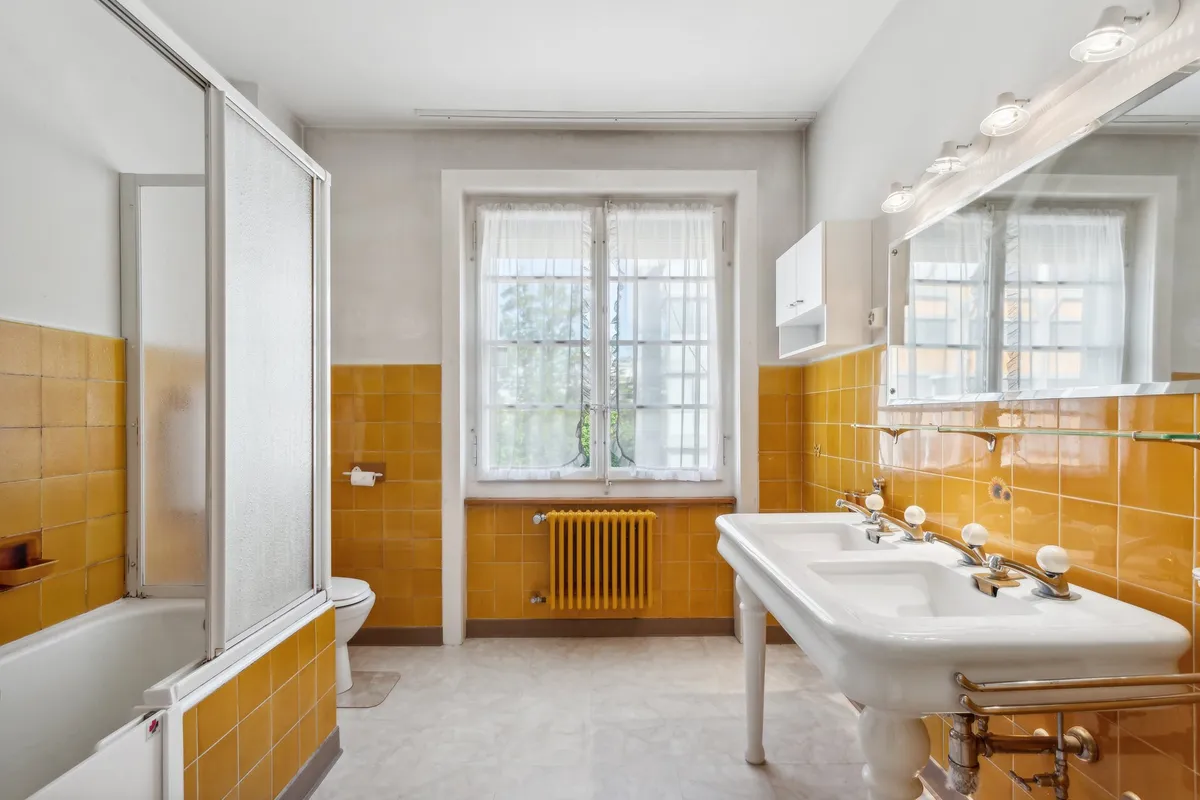 Badezimmer mit gelben Fliesen und Doppelwaschtisch