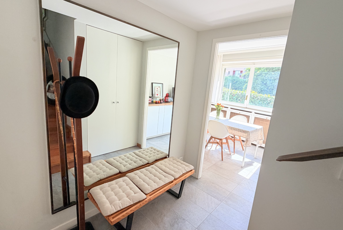 Heller Eingangsbereich mit Garderobe und Blick in den Wintergarten