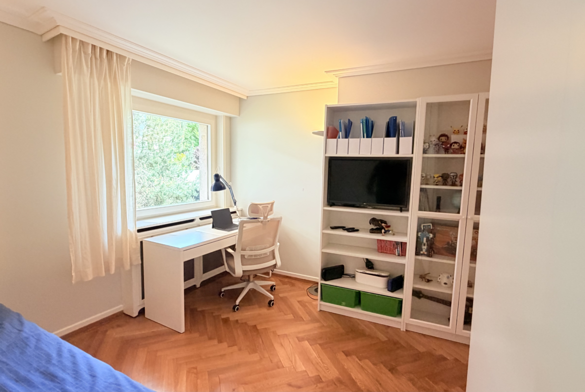 Helles Kinder- oder Arbeitszimmer mit Schreibtisch und Regal