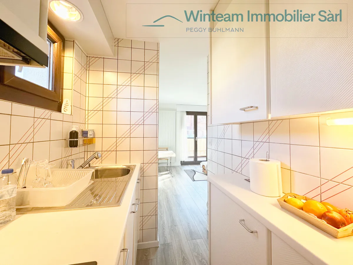 Schmale helle Küche mit Blick in einen Wohnraum