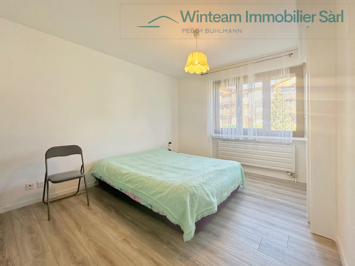 Schlichtes Schlafzimmer mit Bett und Fenster