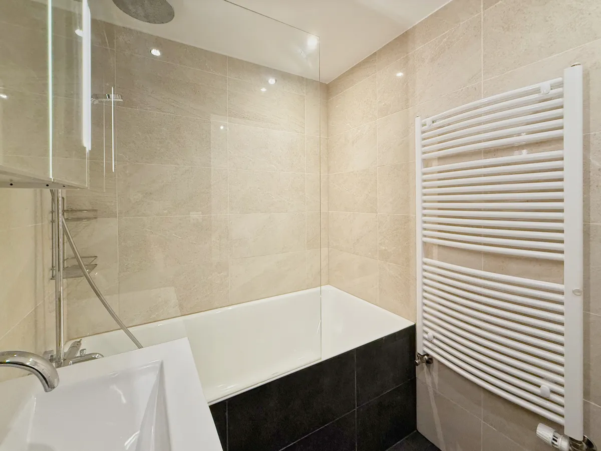 Modernes Badezimmer mit Badewanne und Handtuchheizkörper