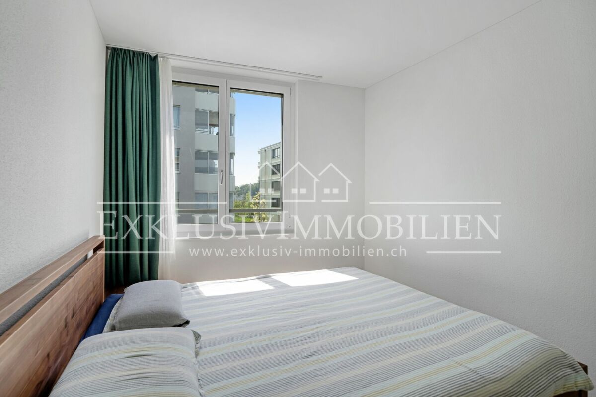 Helles Schlafzimmer mit Bett und Fensterblick