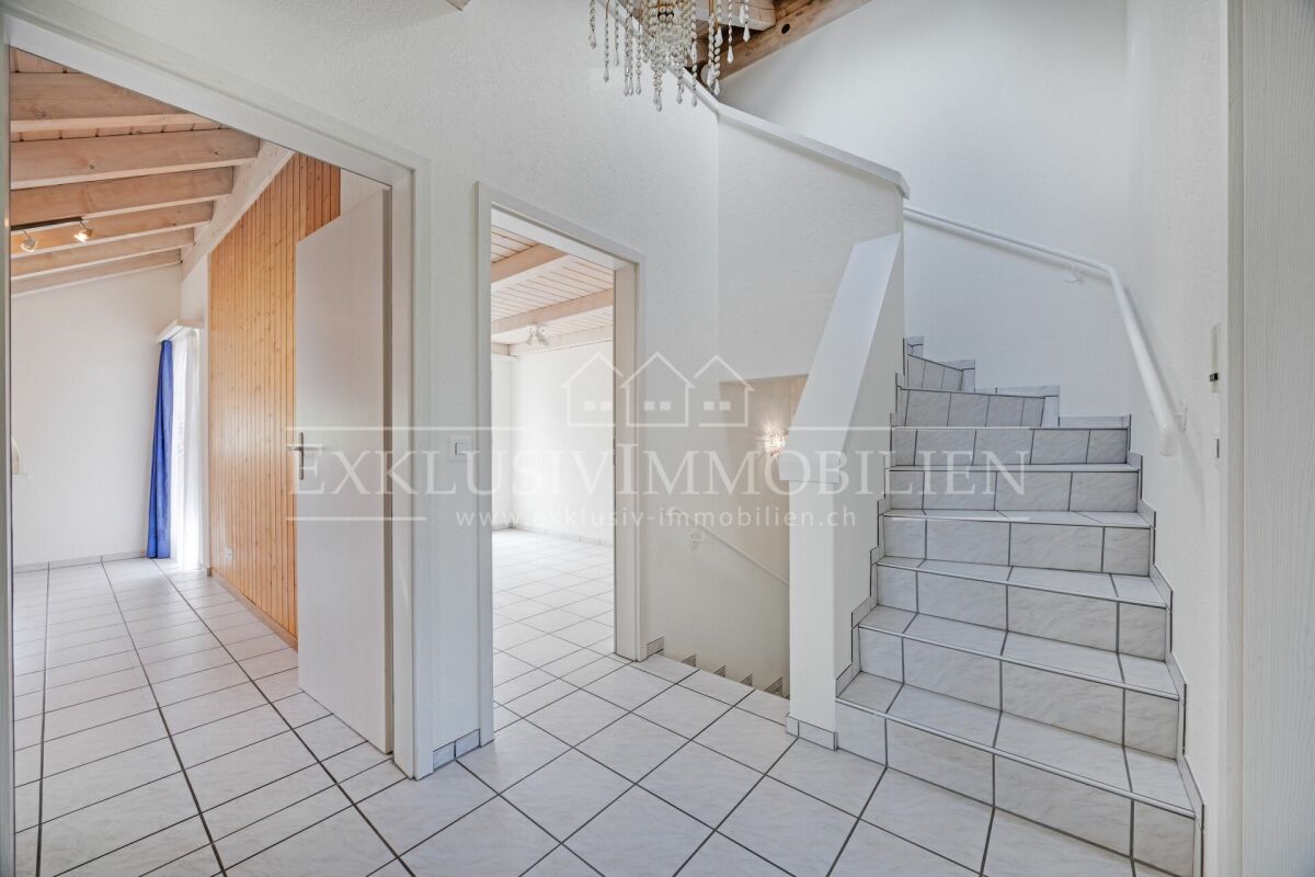 Treppenhaus mit Fliesenboden und offenen Durchgängen