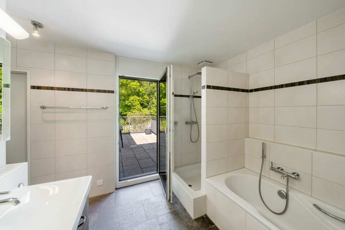 Modernes Badezimmer mit Badewanne und Blick ins Grüne
