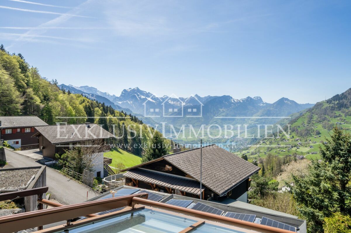 Alpenblick mit Wohnhäusern und Solarpaneelen