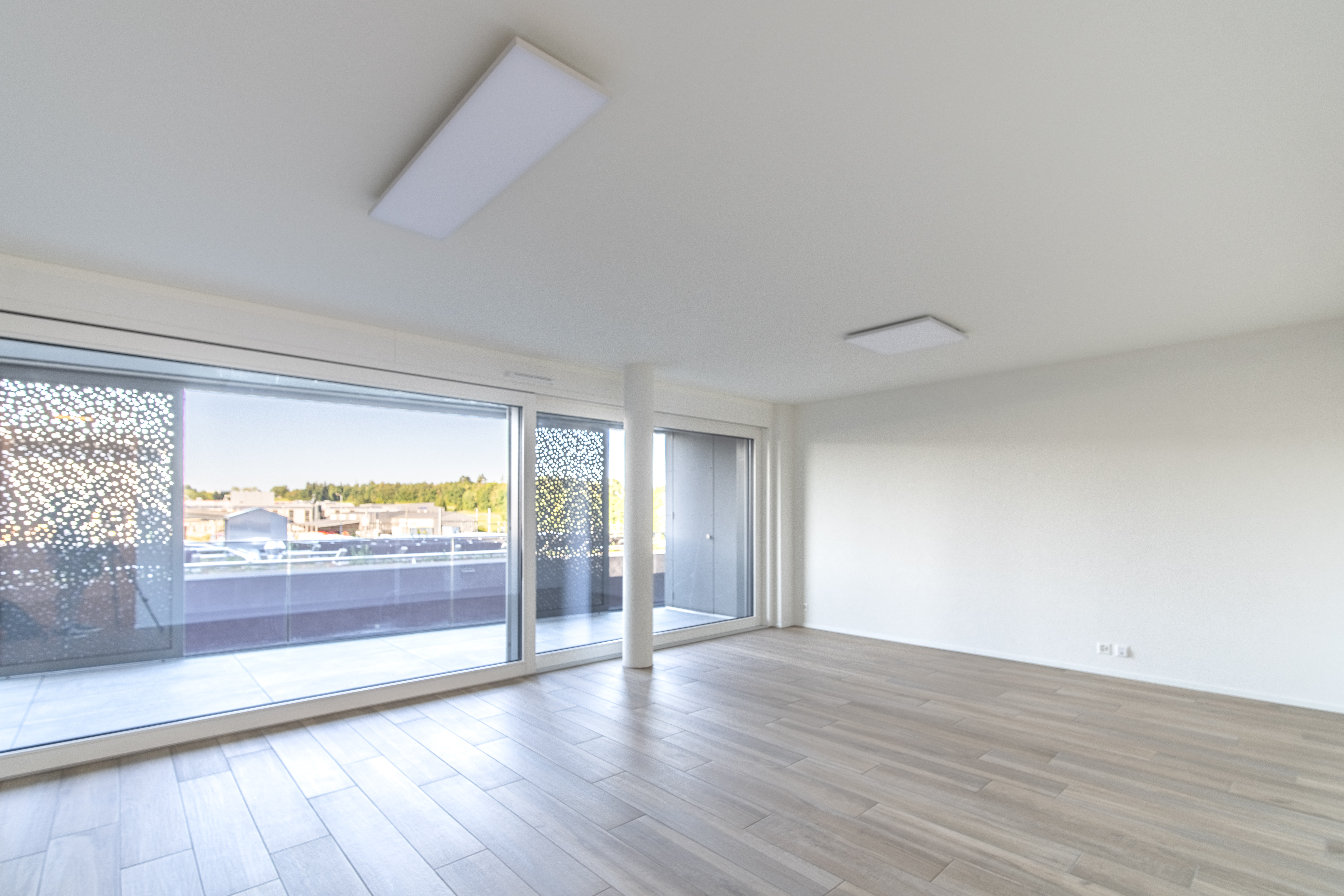 Heller leerer Wohnraum mit großer Fensterfront