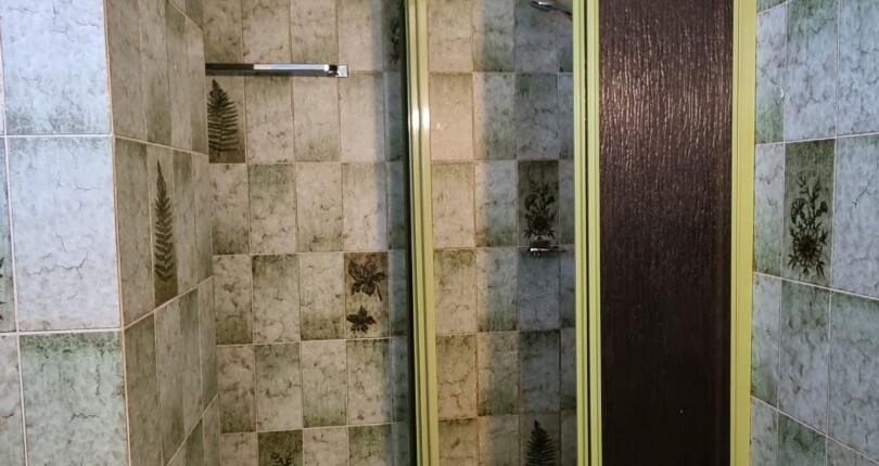 Dusche mit gefliesten Wänden