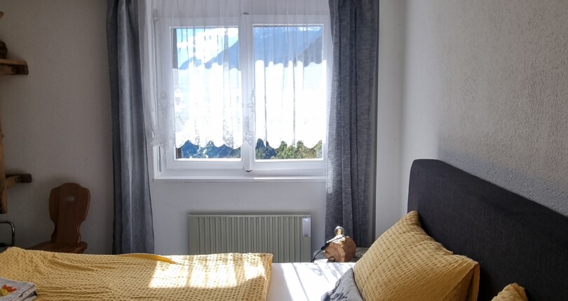 Helles Schlafzimmer mit Fenster und Bett