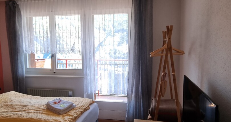 Helles Schlafzimmer mit Fenster und Garderobenständer