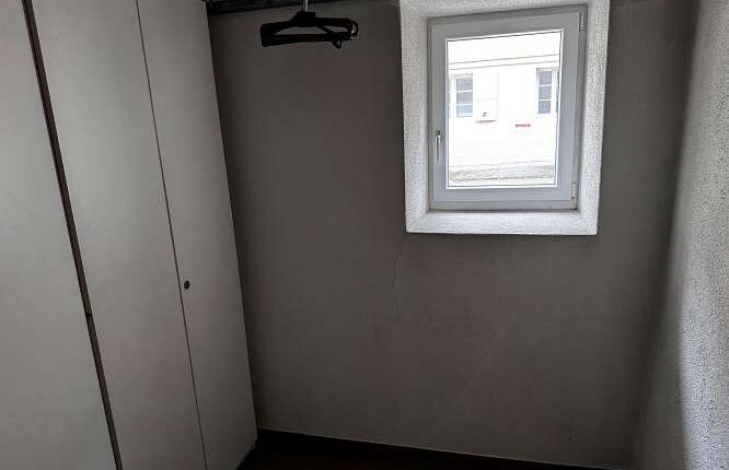 Kleiner Raum mit Fenster und Einbauschrank