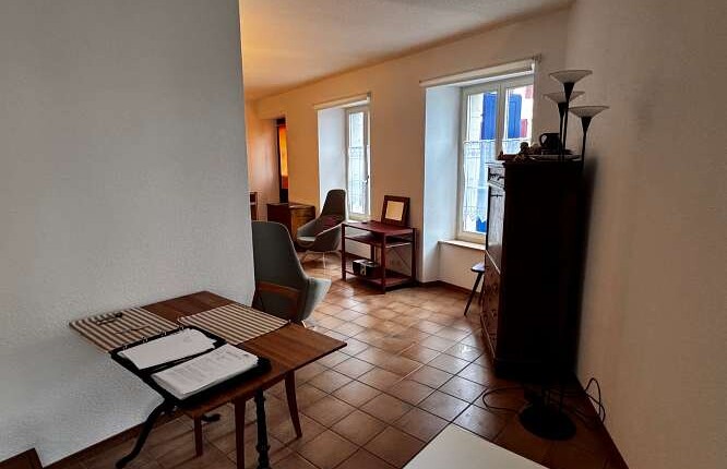 Wohnraum mit Fliesenboden und zwei Fenstern