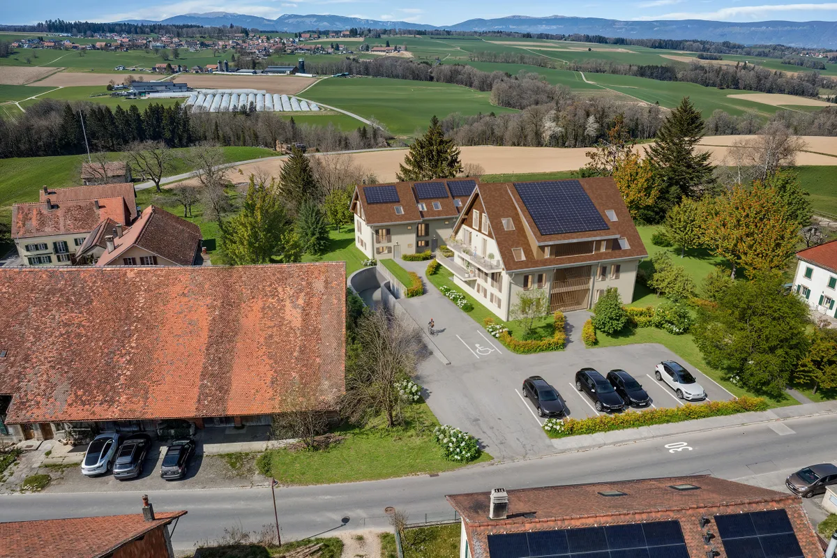 Luftaufnahme eines ländlichen Wohnensembles mit Photovoltaik