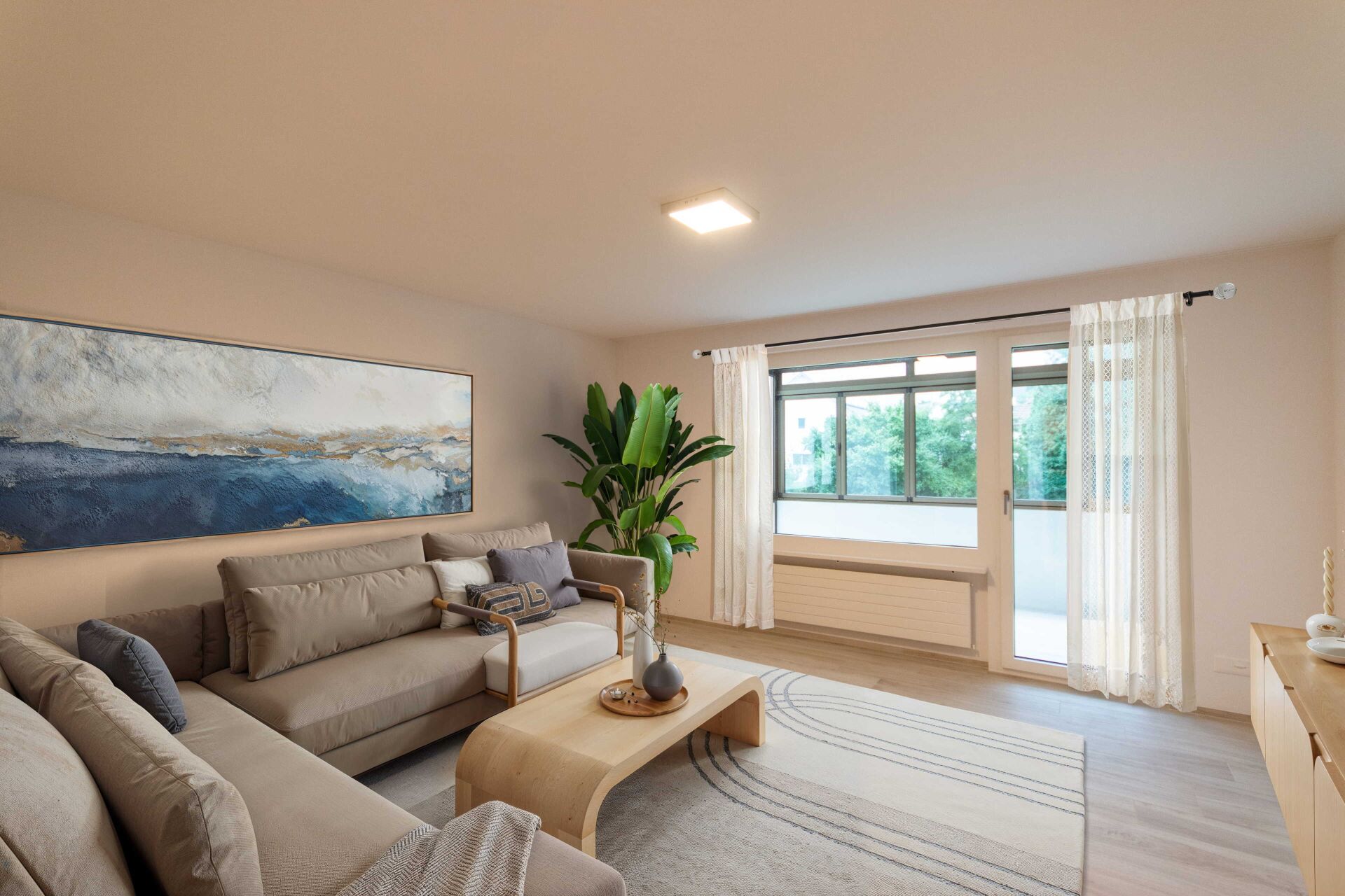 Helles Wohnzimmer mit Sofa und Balkonfenster