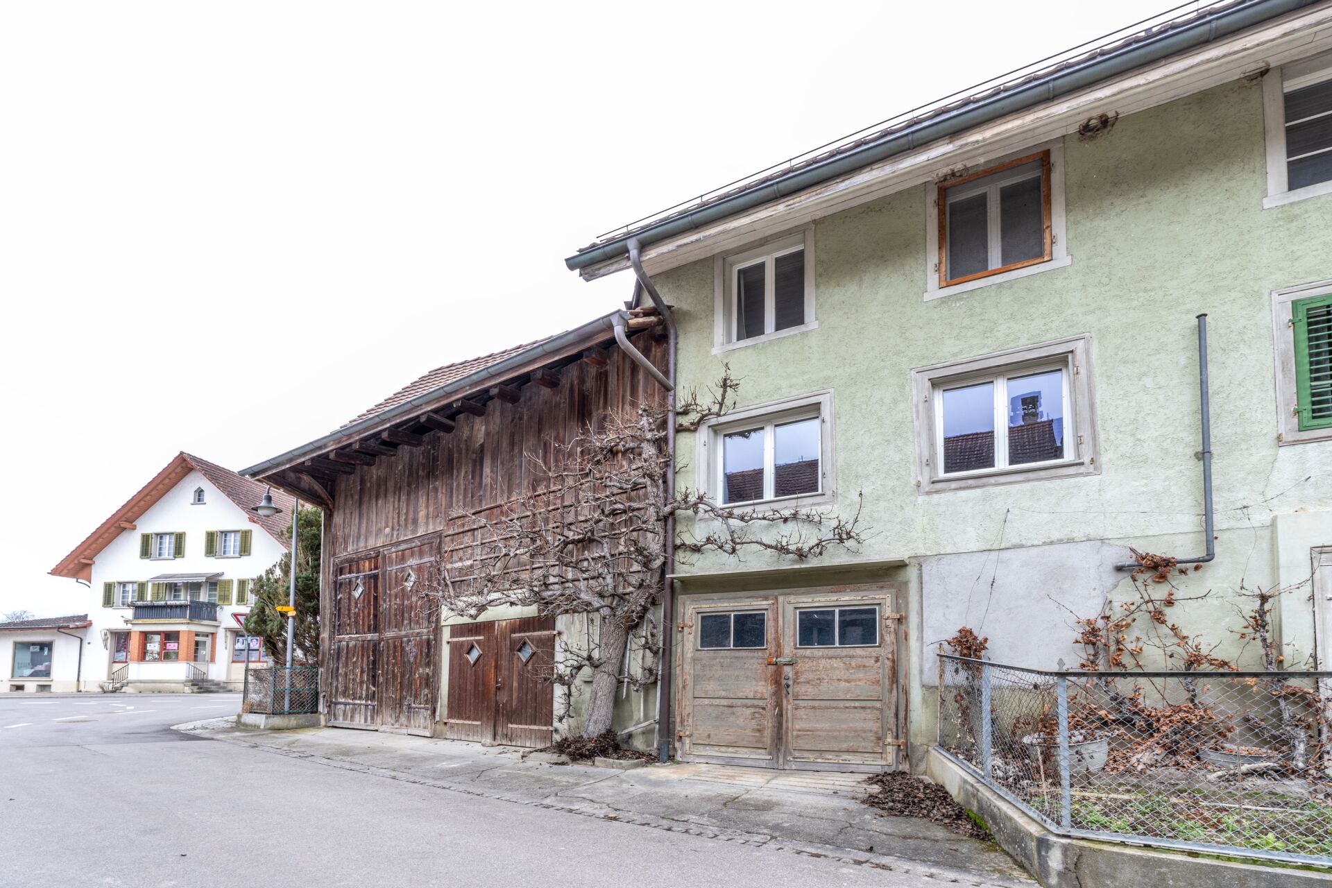 Ländliche Straßenansicht mit Wohnhaus und Nebengebäude
