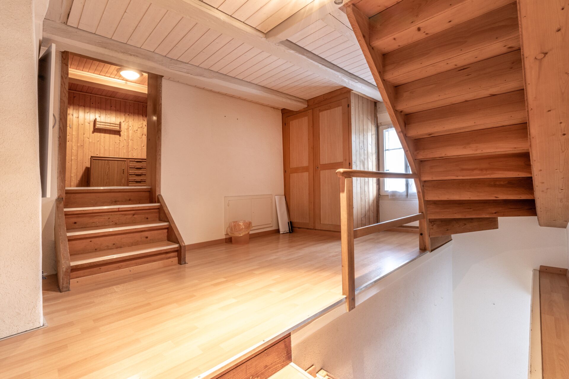 Heller Treppenflur mit Holztreppe