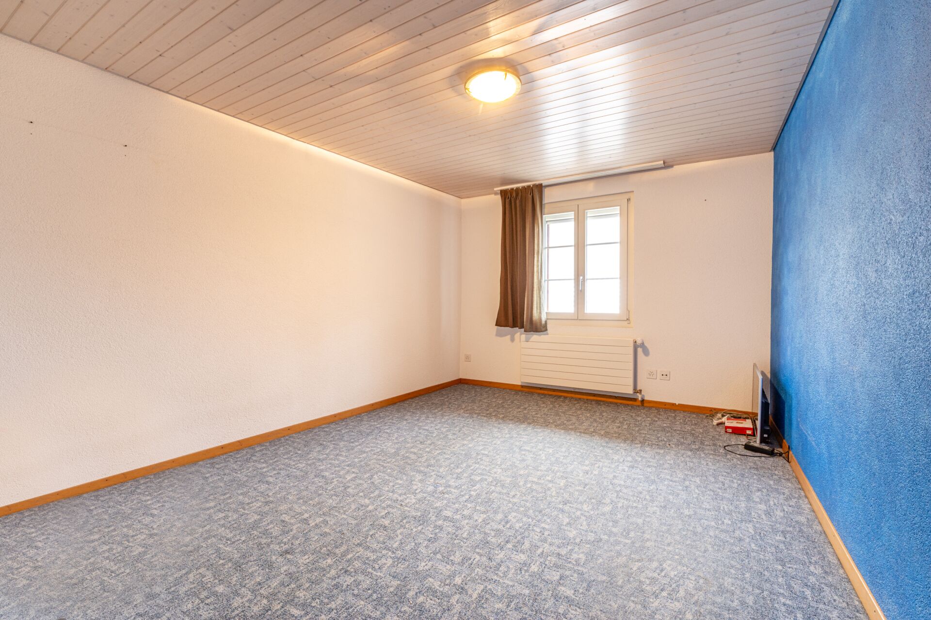 Leerer Innenraum mit Teppichboden und Holzdecke