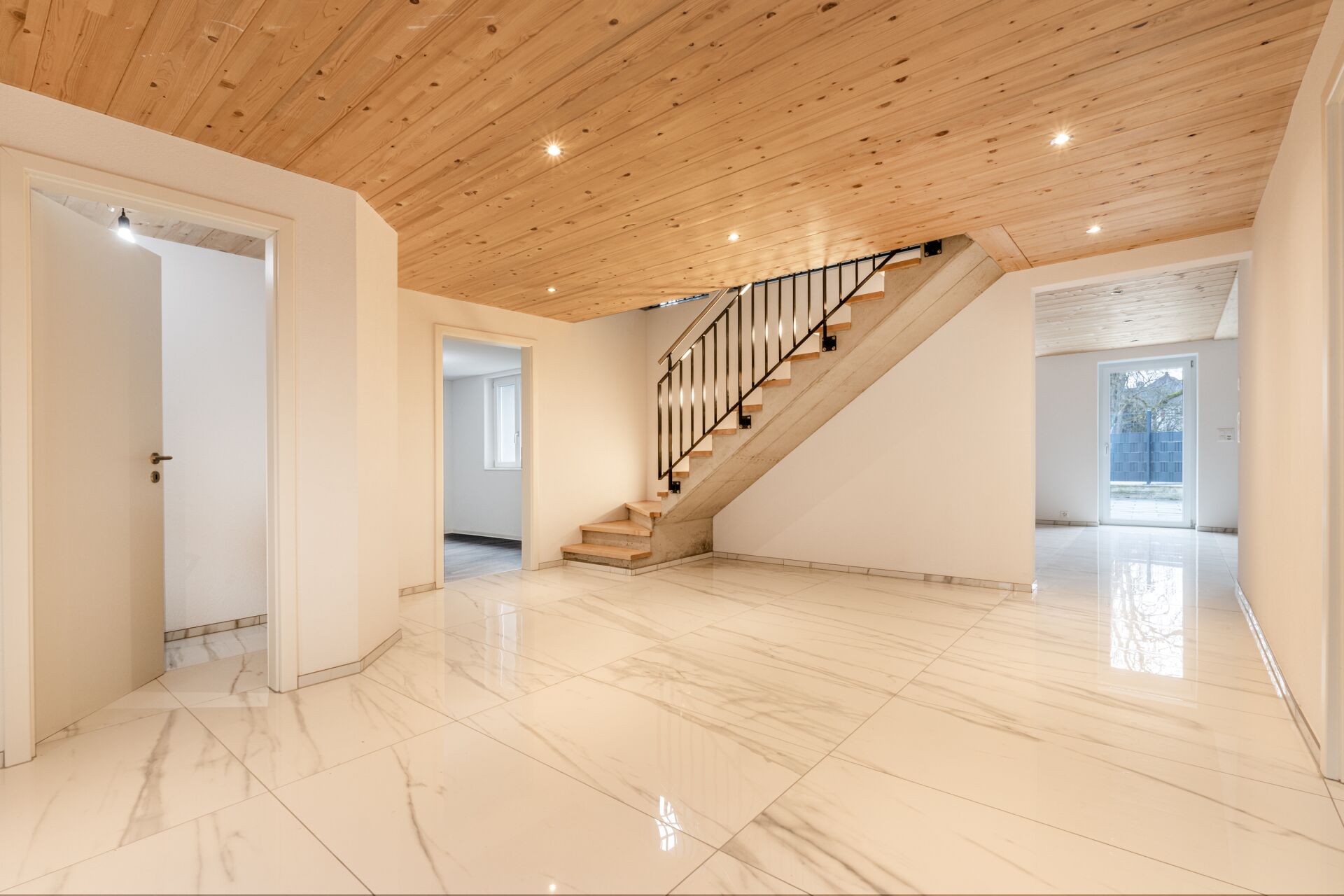 Heller Eingangsbereich mit Treppe und Holzdecke