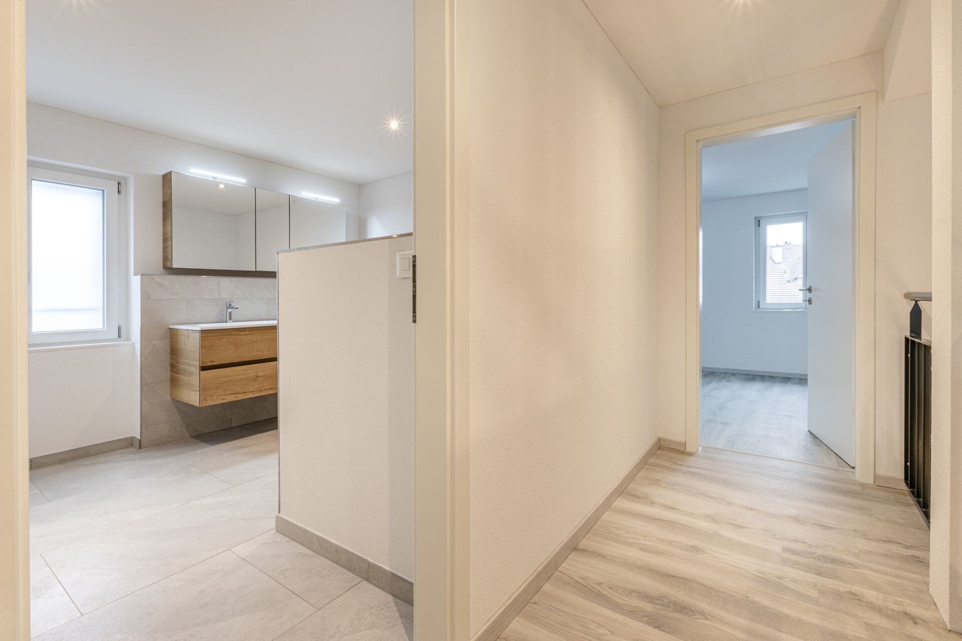 Heller Flur mit angrenzendem Bad und Blick in ein weiteres Zimmer