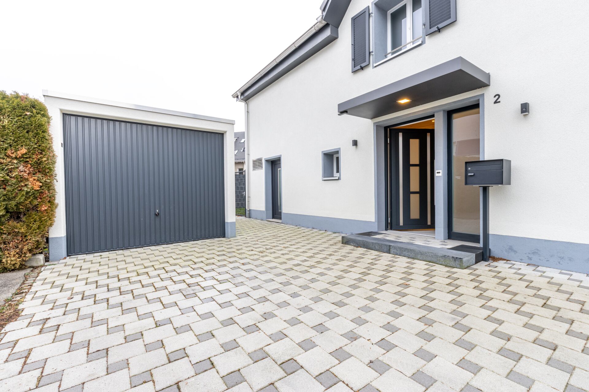Außenansicht eines modernen Wohnhauses mit Garage und Eingangsbereich