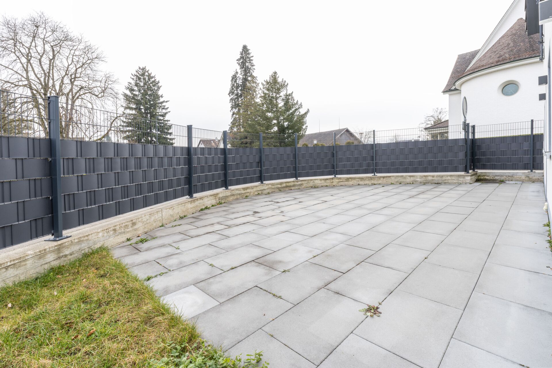Große gepflasterte Terrasse mit Zaunanlage