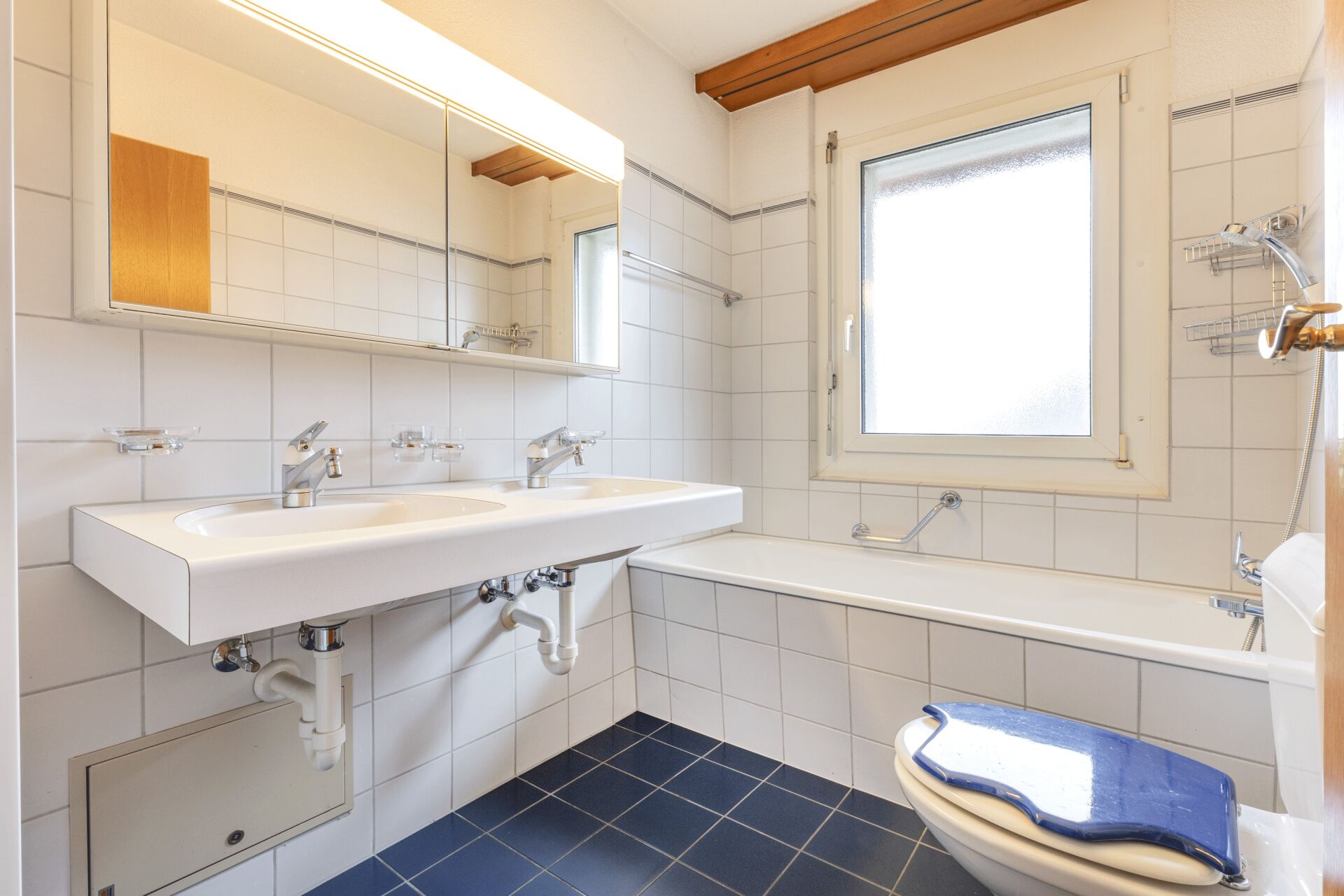 Kleines Badezimmer mit Doppelwaschtisch und Badewanne