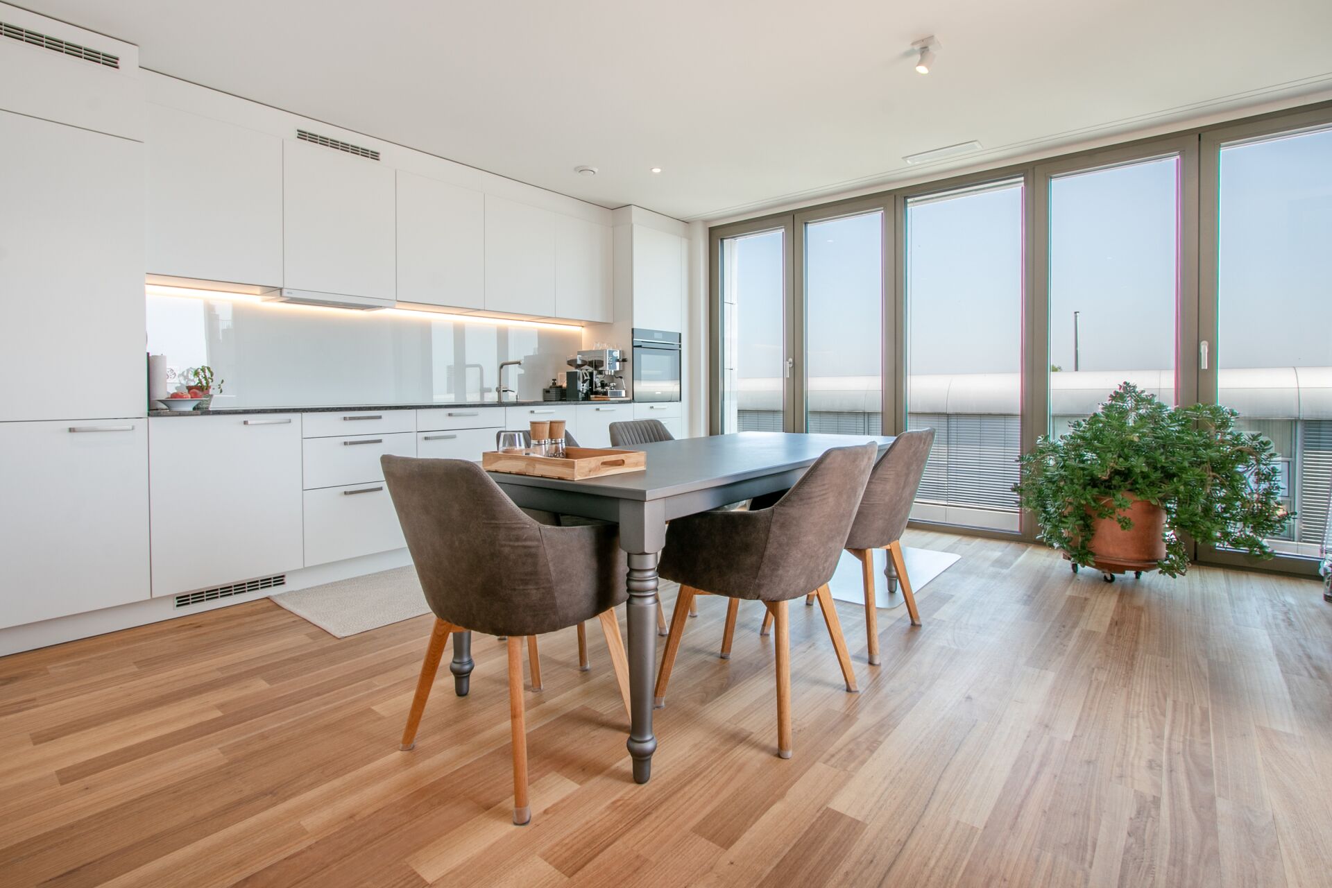 Moderne Wohnküche mit Essbereich und Balkonblick