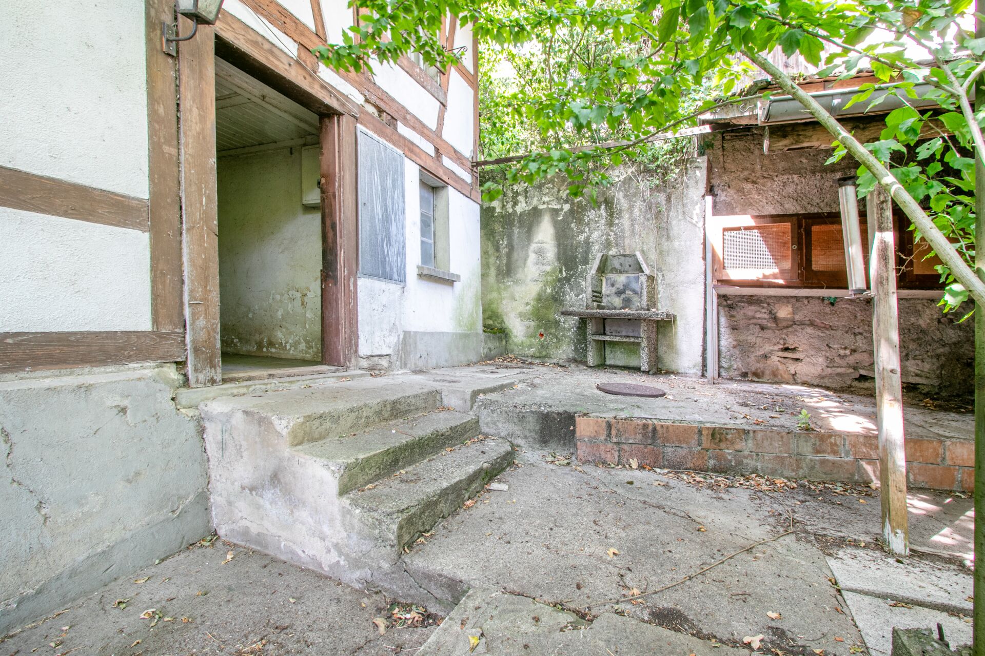 Verwachsener Außenhof mit Altbau- und Nebenbau-Struktur