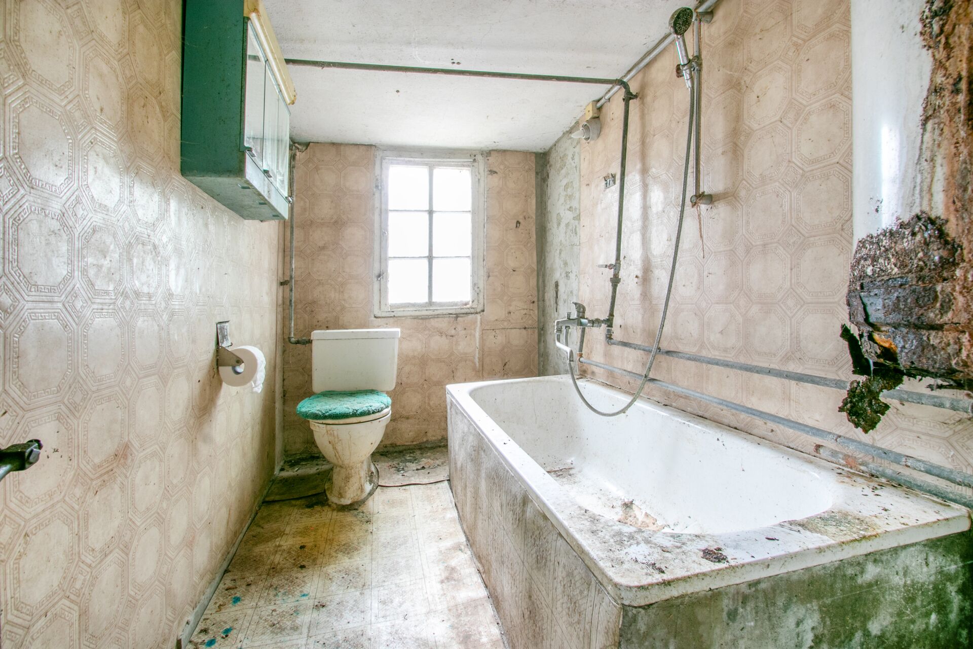 Veraltetes Badezimmer mit Badewanne und WC