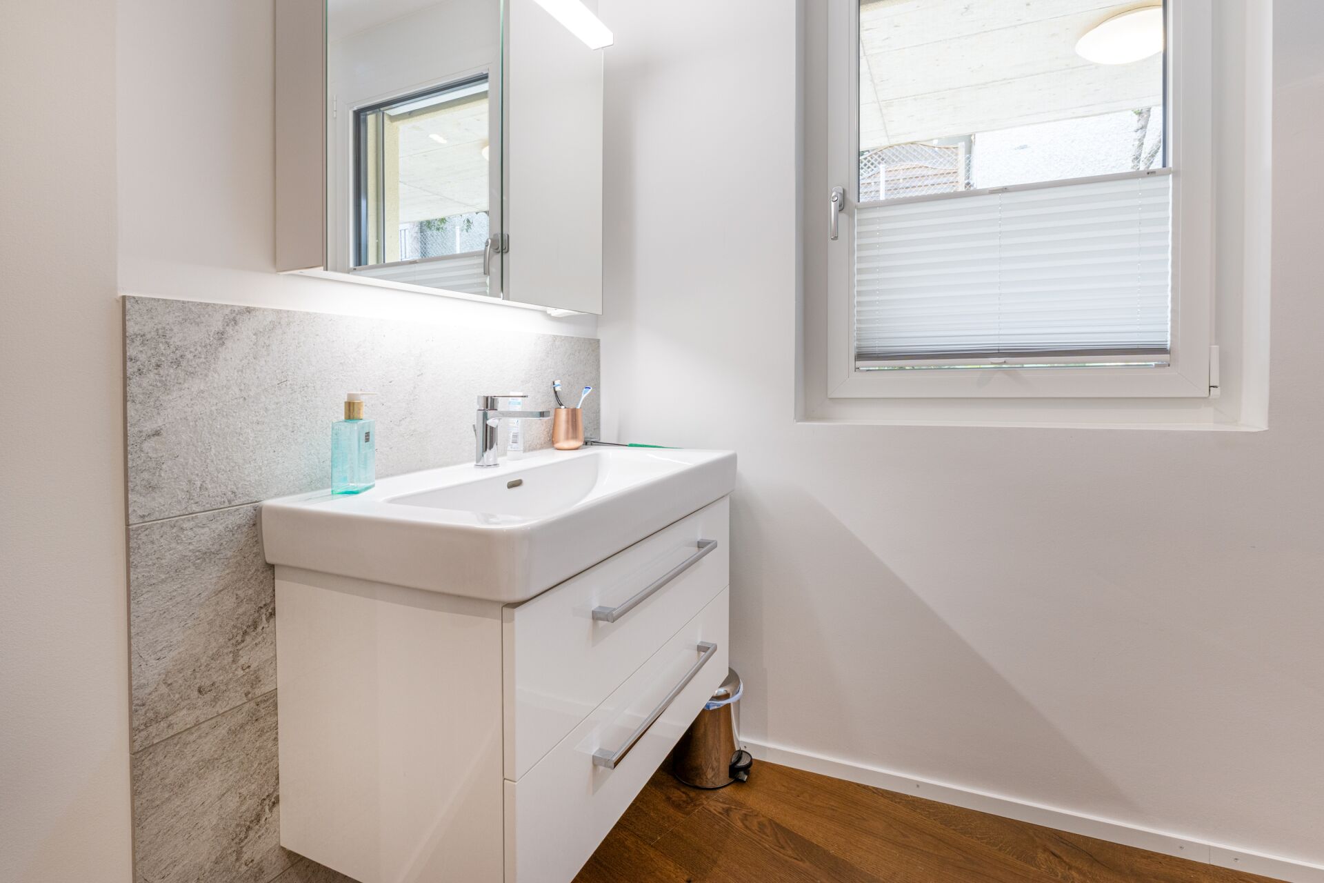 Helles Badezimmer mit Waschtisch und Fenster