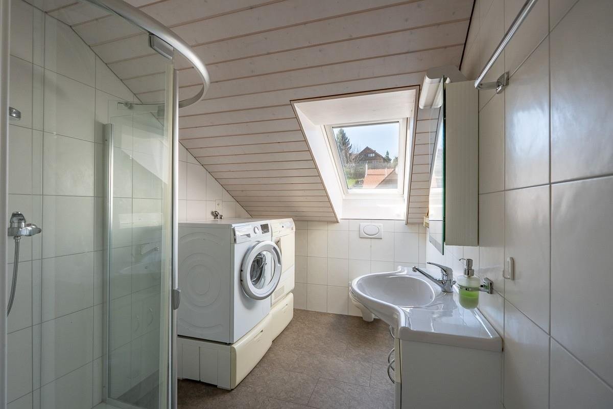 Helles Dachgeschoss-Badezimmer mit Waschmaschinenbereich
